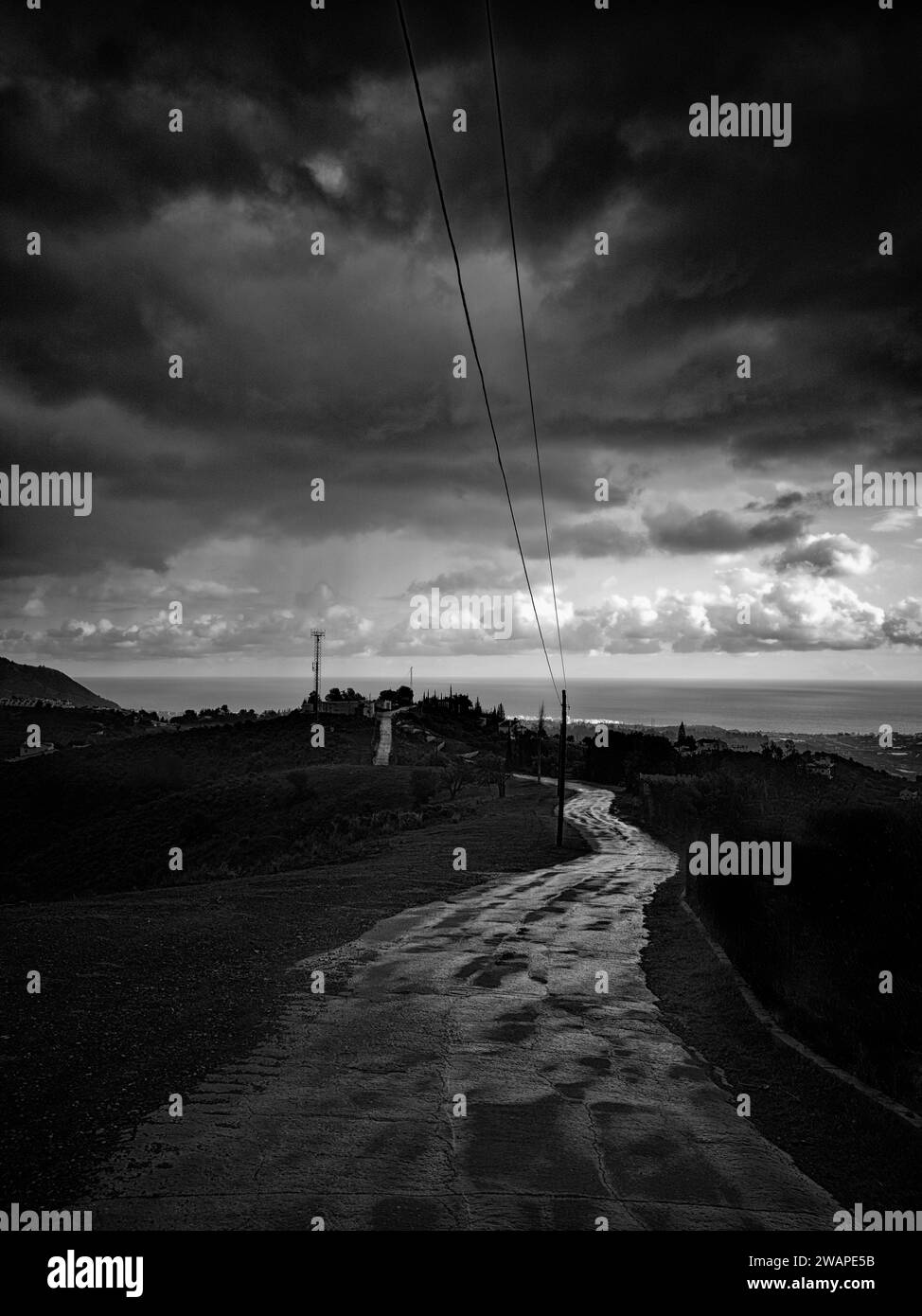 La pluie en Espagne dérivant vers la côte méditerranéenne. Mis en évidence par la faible lumière, une route à travers les collines menant à Nerja sur la Costa del sol, Banque D'Images