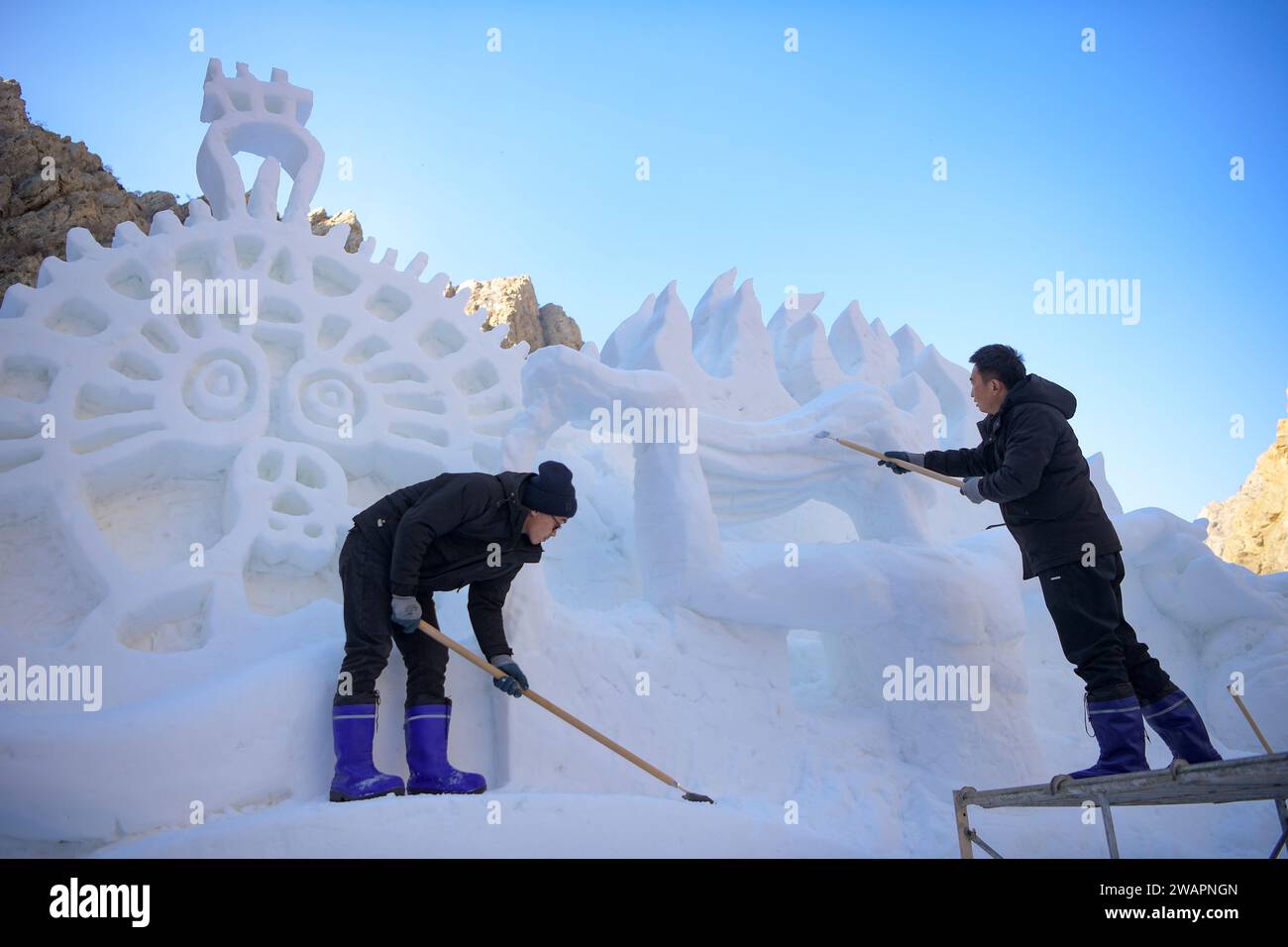 Yinchuan. 5 janvier 2024. Les membres du personnel créent une sculpture de neige dans la zone pittoresque de peinture de falaise de la montagne Helan dans la région autonome hui de Ningxia, dans le nord-ouest de la Chine, le 5 janvier 2024. Crédit : Feng Kaihua/Xinhua/Alamy Live News Banque D'Images