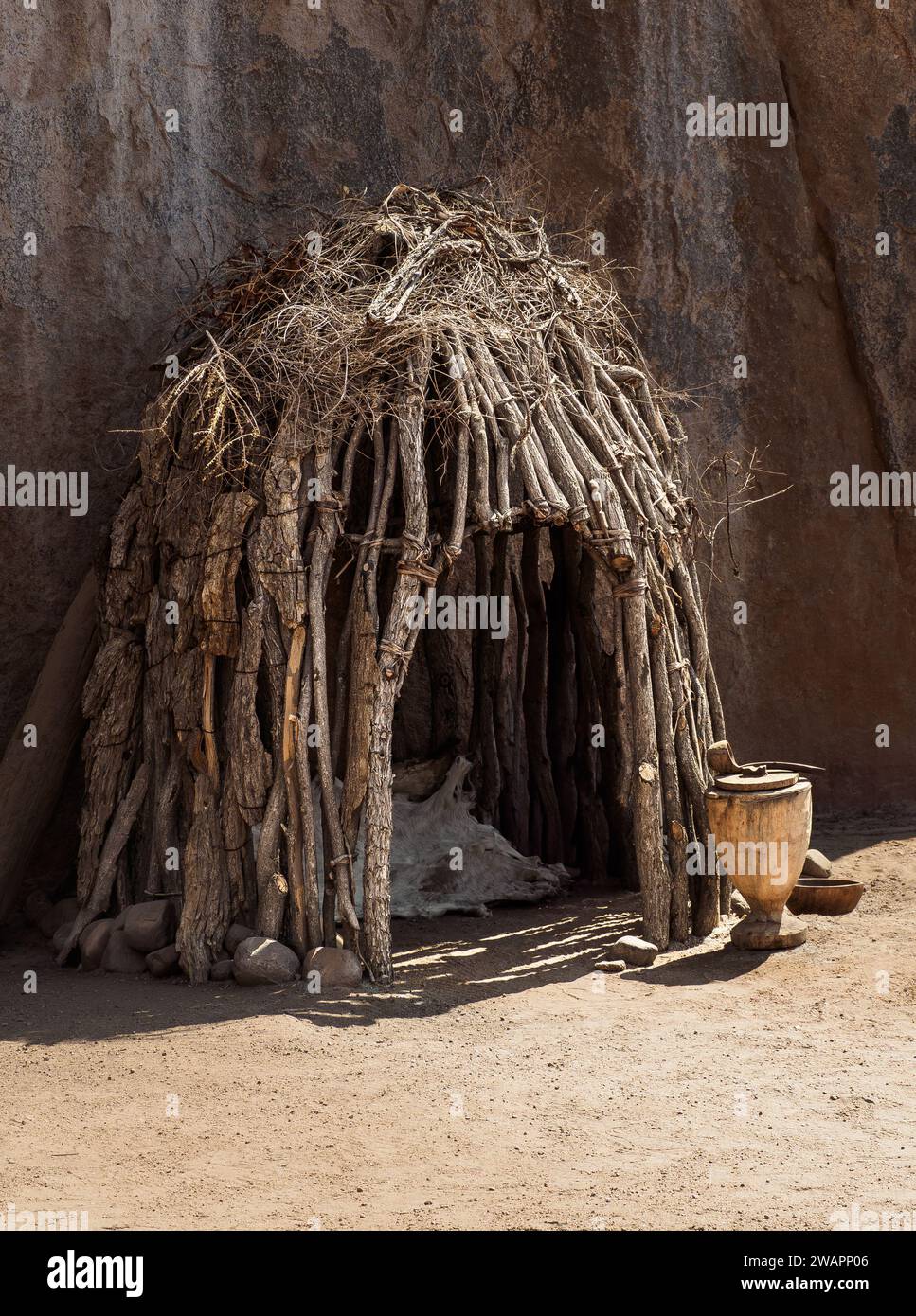 Cabane en bois près de la paroi rocheuse dans le village de la tribu Damara faite à partir de branches sèches, Afrique australe. Traditions culturelles des housin indigènes africains Banque D'Images