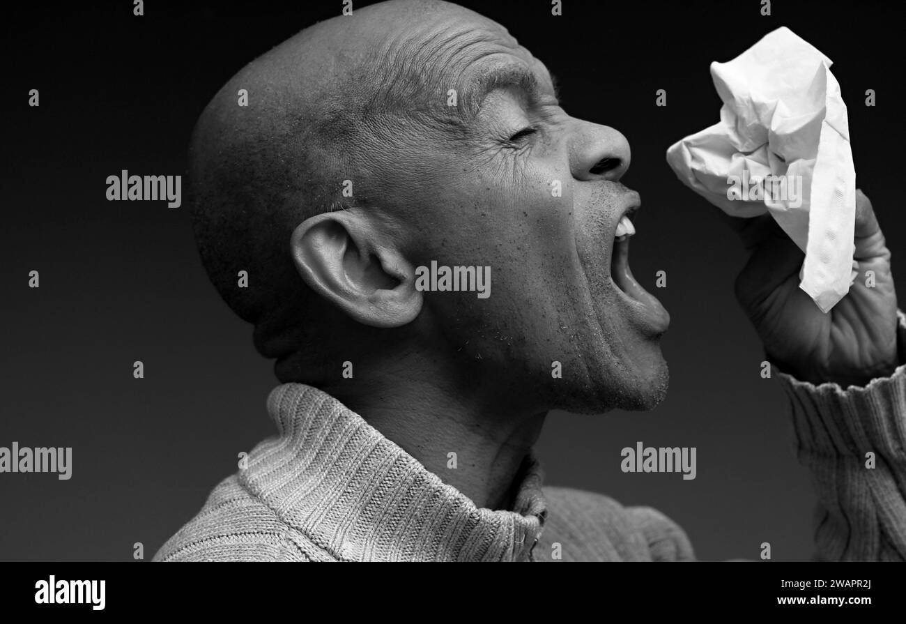 soufflant nez après avoir attrapé le rhume et la grippe avec fond gris avec des gens stock image photo Banque D'Images