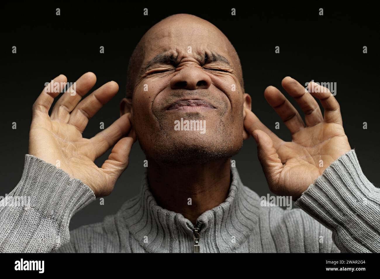 homme sourd souffrant de surdité et de perte auditive sur fond noir gris avec des gens stock image photo Banque D'Images