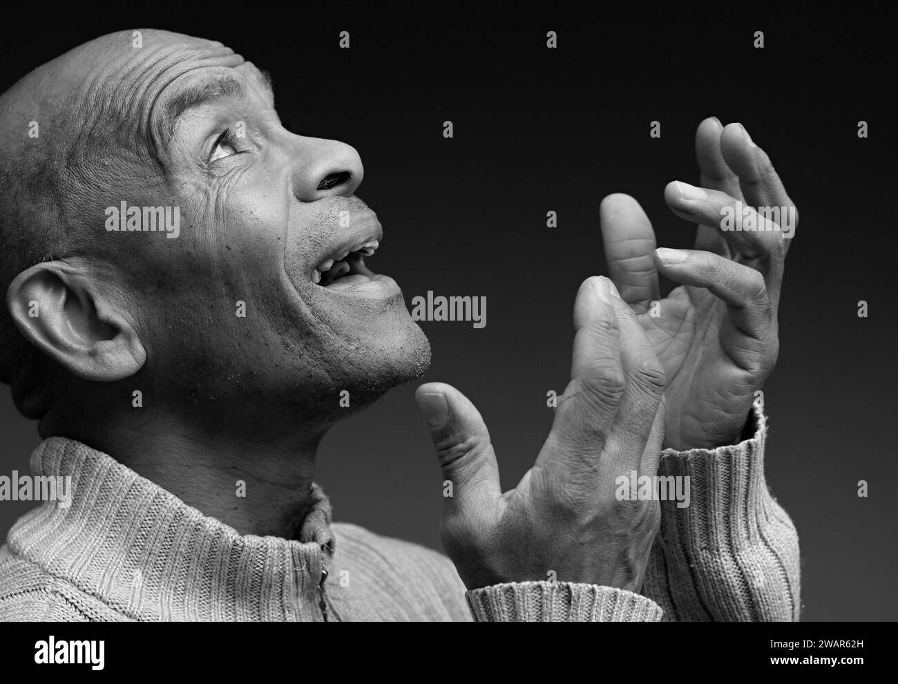 Prier dieu pour le pardon homme des Caraïbes priant avec fond noir gris avec des gens stock image photo Banque D'Images