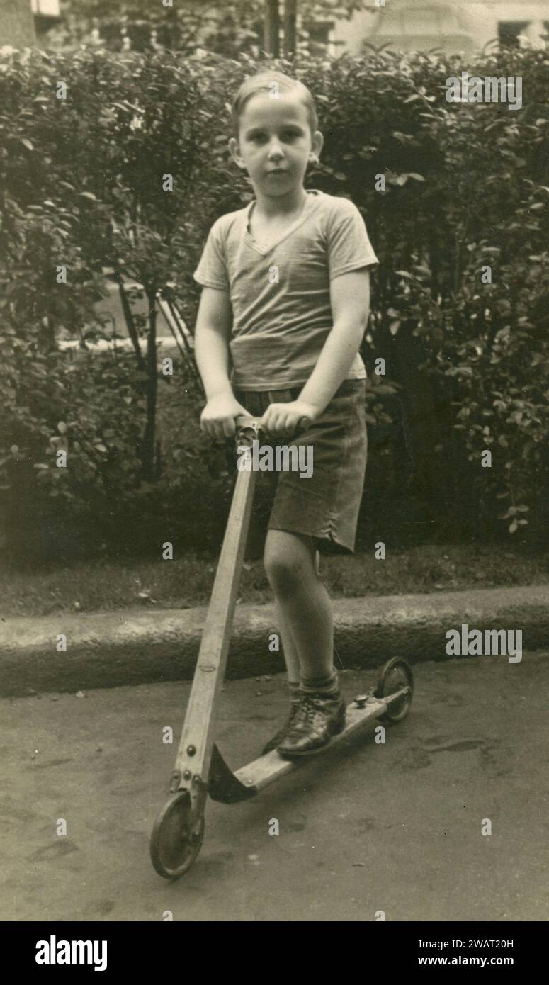 Petit garçon sur scooter en bois, années 1950 Banque D'Images