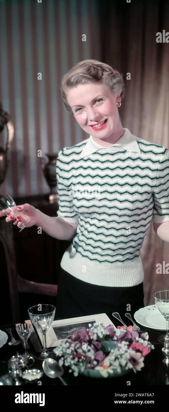 Années 1950, historique, une dame modelant un pull rayé en laine tricotée, Angleterre, Royaume-Uni. Les vêtements en laine étaient à la mode dans les années 40 et 50 parce qu'ils étaient féminins, simples et classiques dans le style. Banque D'Images