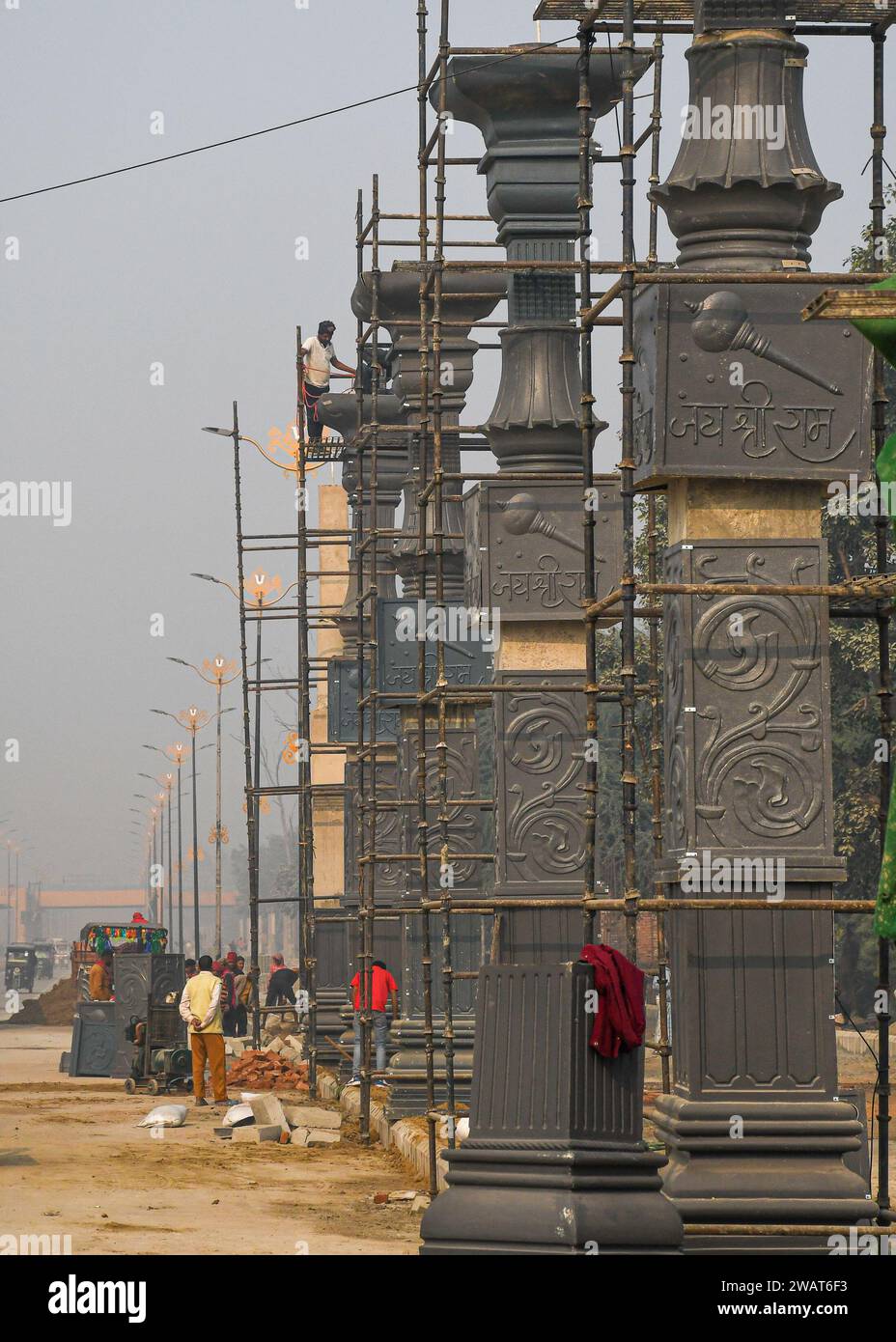 Ayodhya, Inde. 27 décembre 2023. Des ouvriers installent des matériaux de construction avant la visite du Premier ministre indien Narendra Modi à Ayodhya. Ramnagari Ayodhya, autrefois connu pour ses rues étroites et ses routes en décomposition, progresse régulièrement : toutes les routes et bâtiments menant à RAM Janmabhoomi sont en cours d’élargissement et de rénovation pour faciliter les déplacements. (Photo de Biplov Bhuyan/SOPA Images/Sipa USA) crédit : SIPA USA/Alamy Live News Banque D'Images