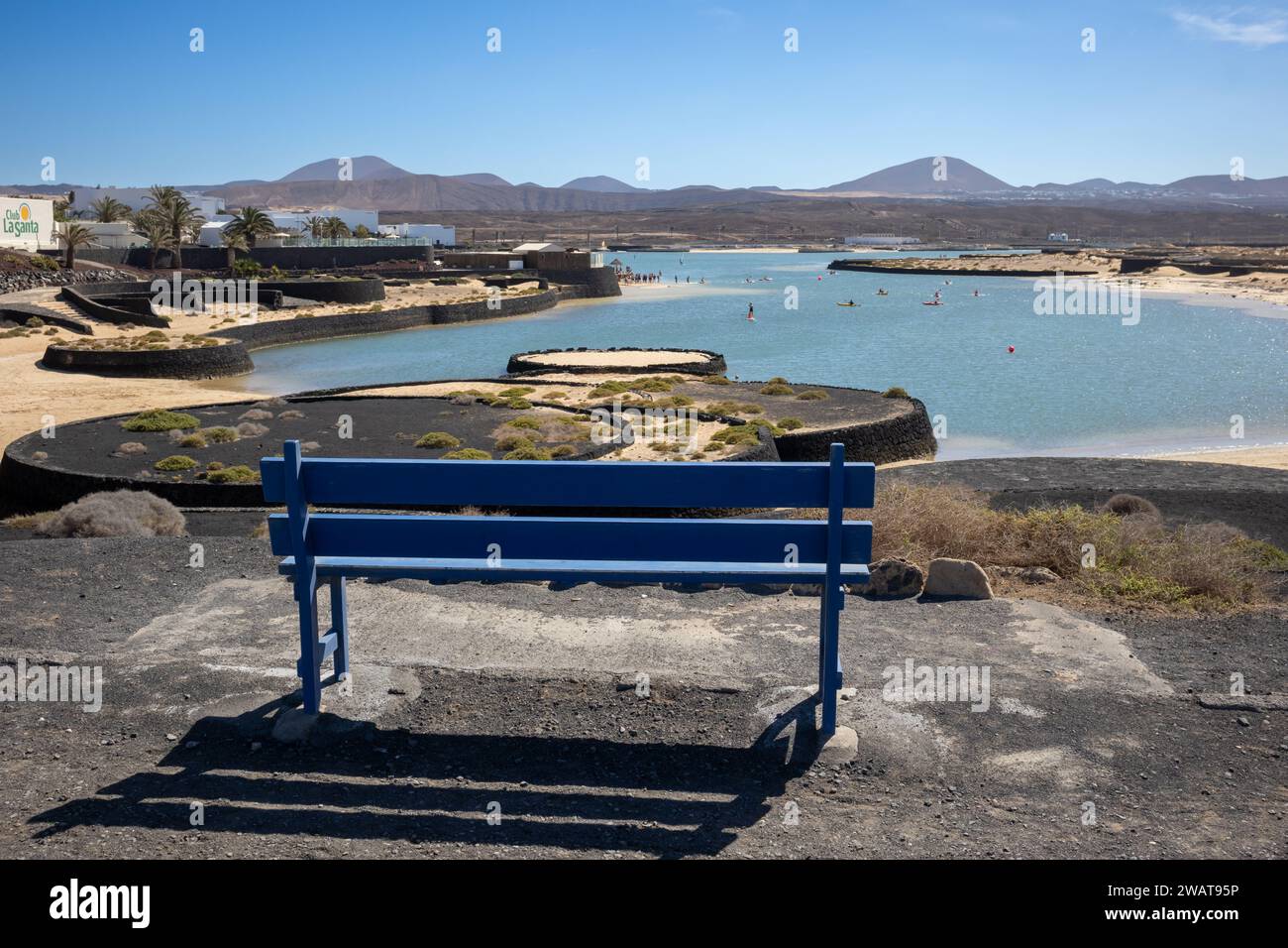 Banc avec vue sur une baie de l'océan Atlantique avec une plage de sable jaune très basse. Montagnes en arrière-plan. ciel bleu avec un nuage léger dedans Banque D'Images