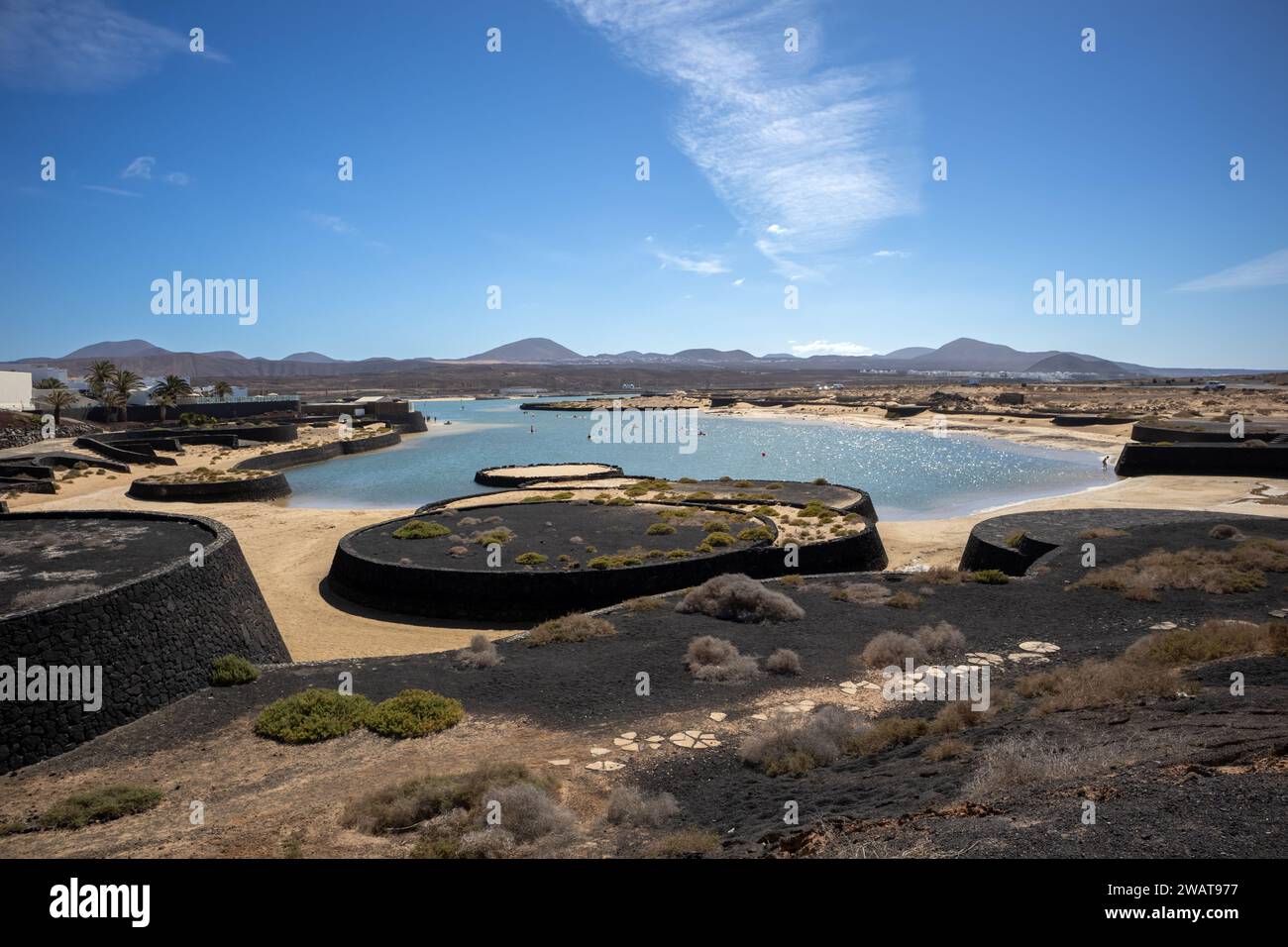 Baie de l'océan Atlantique avec une eau très basse, entourée d'une plage de sable jaune. Montagnes en arrière-plan. ciel bleu avec un nuage léger dans la lucarne Banque D'Images