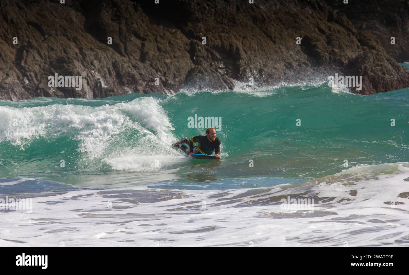 Body boarder attrapant le brise-roche à Kynance Cove, Cornwall. Couper la vague. Banque D'Images