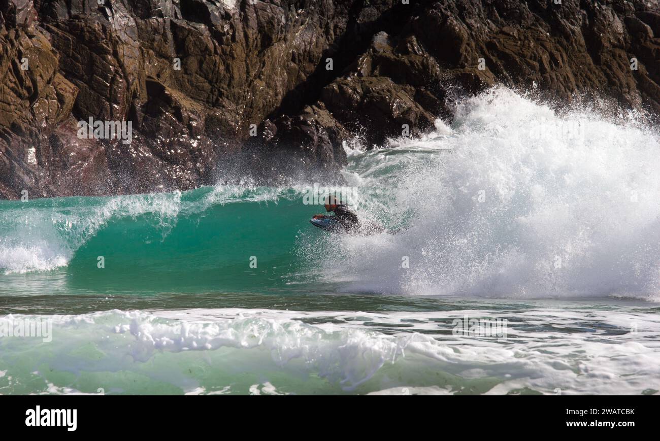 Body boarder attrapant le brise-roche à Kynance Cove, Cornwall. Banque D'Images