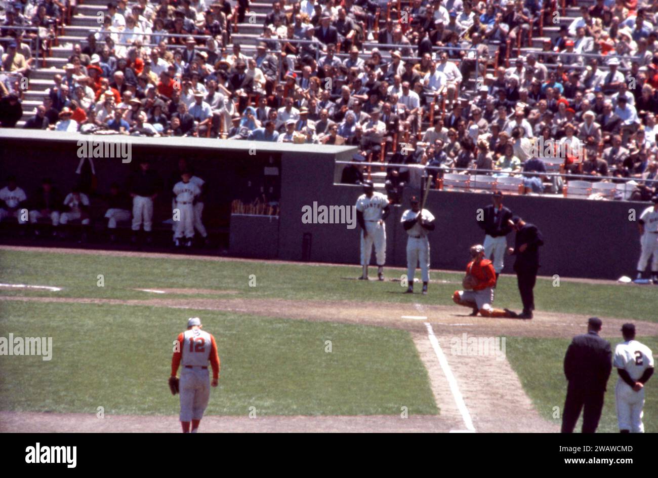 SAN FRANCISCO, CA - 30 MAI : Willie Mays #24 des Giants de San Francisco attend sur le pont alors que le receveur Jerry Zimmerman #8 des Reds de Cincinnati réchauffe le nouveau lanceur lors d'un match MLB le 30 mai 1961 au Candlestick Park à San Francisco, Californie. Le troisième joueur de base des Reds est Gene Freese #12, le troisième entraîneur des Giants est Salty Parker #2 et l'arbitre Frank Secory. (Photo de Hy Peskin) *** Légende locale *** Jerry Zimmerman;Gene Freese;Willie Mays;Frank Secory;Salty Parker Banque D'Images