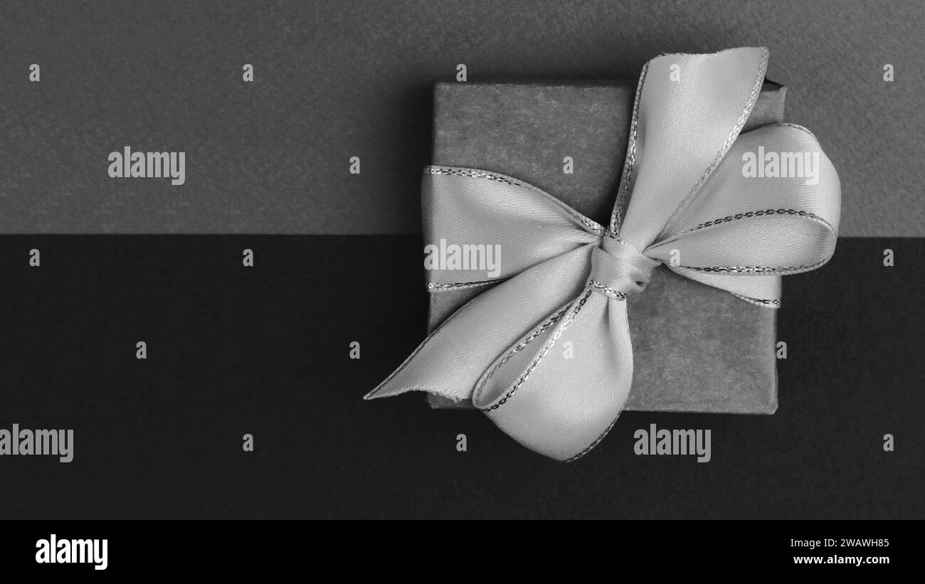 Vue de dessus d'une boîte cadeau en papier attaché avec un ruban sur un fond de papier... image en noir et blanc d'une boîte cadeau. Banque D'Images