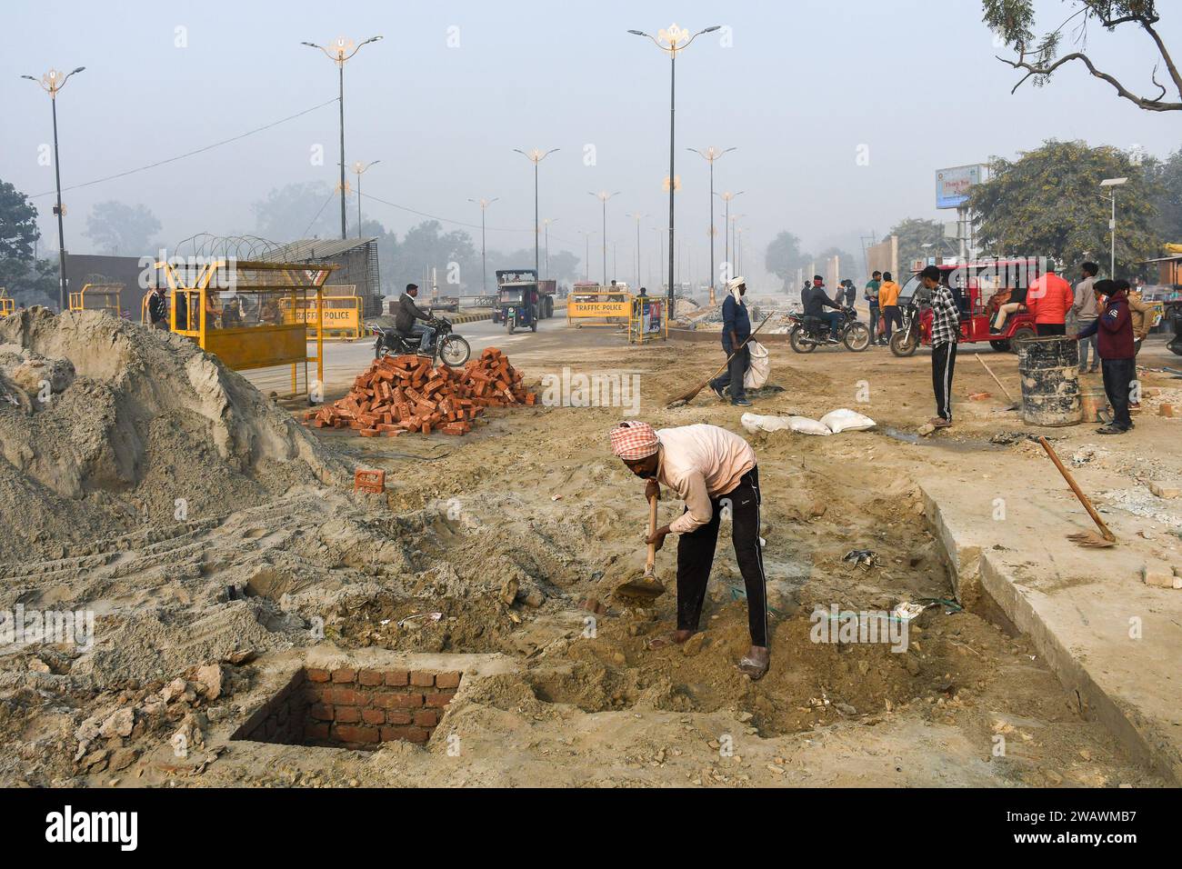 Ayodhya, Inde. 26 décembre 2023. A ouvriers labourent sur des chantiers de construction de routes, avant l'inauguration du temple RAM. Le temple RAM sera inauguré le 22 janvier par le Premier ministre Narendra Modi et le Premier ministre de l'Uttar Pradesh, Yogi Adityanath. Près de 8 000 dignitaires, dont des voyants, des industriels, des VVIPS, des acteurs et des lauréats du Padam Bushan, ont été invités à ce grand événement. (Photo de Biplov Bhuyan/SOPA Images/Sipa USA) crédit : SIPA USA/Alamy Live News Banque D'Images