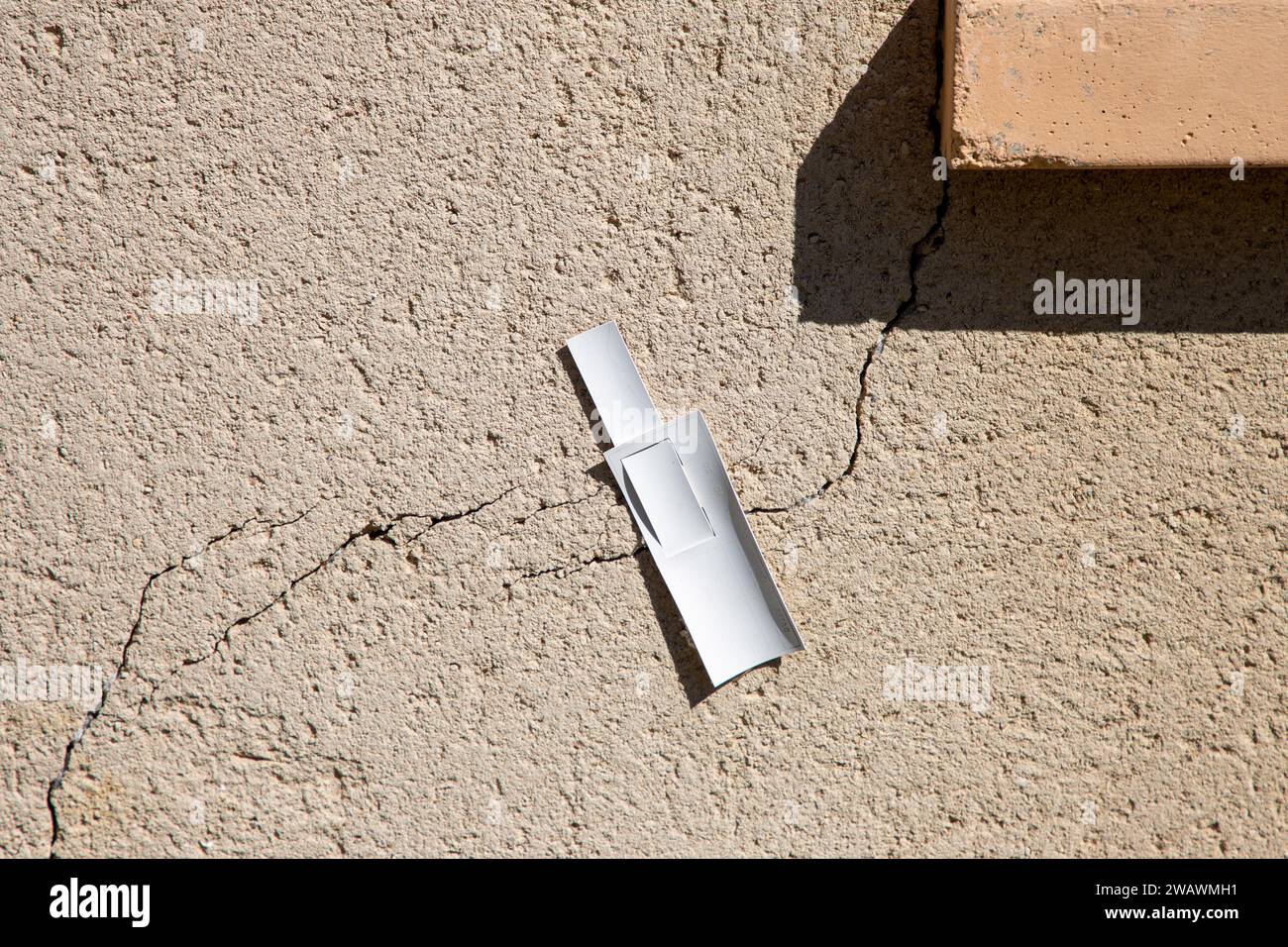 surveiller les variations de largeur de fissure approches pour surveiller les dommages structurels causés par les mouvements du sol ciment de mur au rebord de fenêtre par affaissement de Banque D'Images