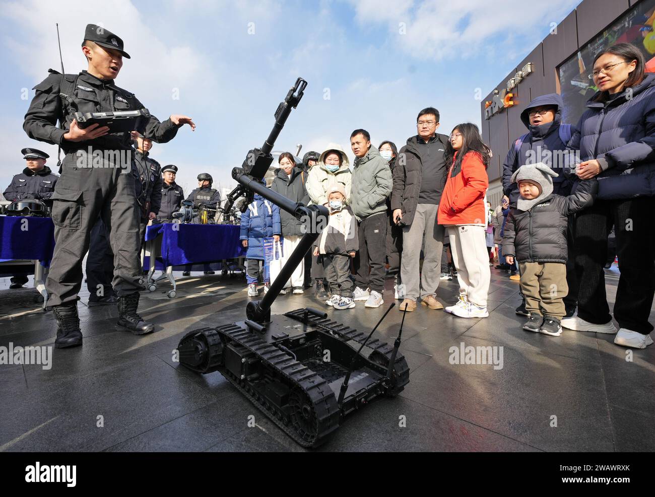 YANTAI, CHINE - le 7 JANVIER 2024 - des citoyens apprennent l'existence d'un robot d'élimination des explosifs de la police sur la place Wanxiang hui à Yantai, dans le Shandong provi de la Chine orientale Banque D'Images