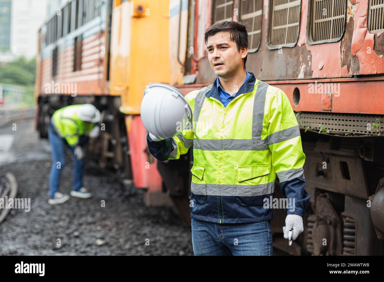 Le travailleur de l'ingénieur fatigue fatiguée des travaux extérieurs par temps chaud de travail dur avec le vieux personnel de service masculin de train diesel Banque D'Images