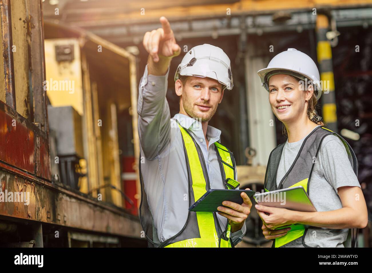 Homme et femmes d'équipe d'officier d'ingénieur travaillant ensemble avec la vérification de tablette inspectent dans l'usine de construction d'industrie lourde. Banque D'Images