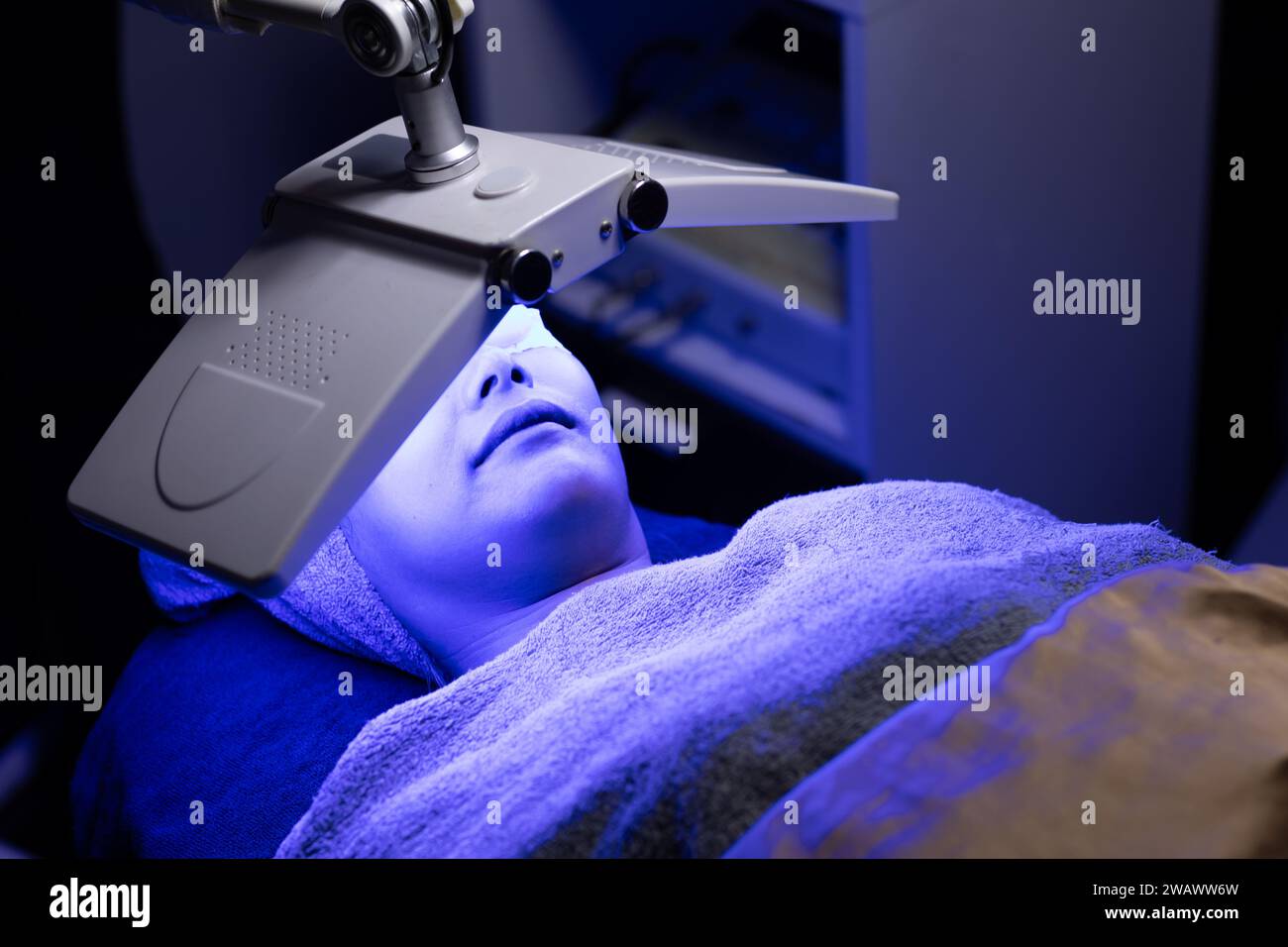 Processus cosmétique facial de femme avec traitement de peau de visage de laser de biolight réparation de rajeunissement de levage dans le spa de beauté de technologie Banque D'Images