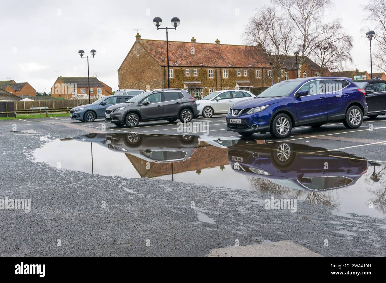 Grande flaque d'eau dans un parking de supermarché suite à de fortes pluies. Banque D'Images