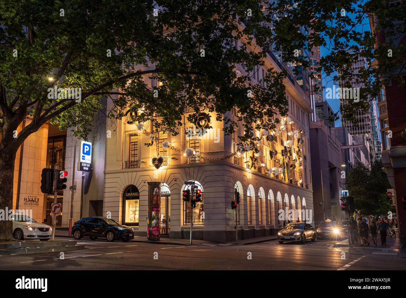 Un bâtiment moderne blanc avec plusieurs fenêtres et un parking rempli de voitures à Melbourne, en Australie Banque D'Images