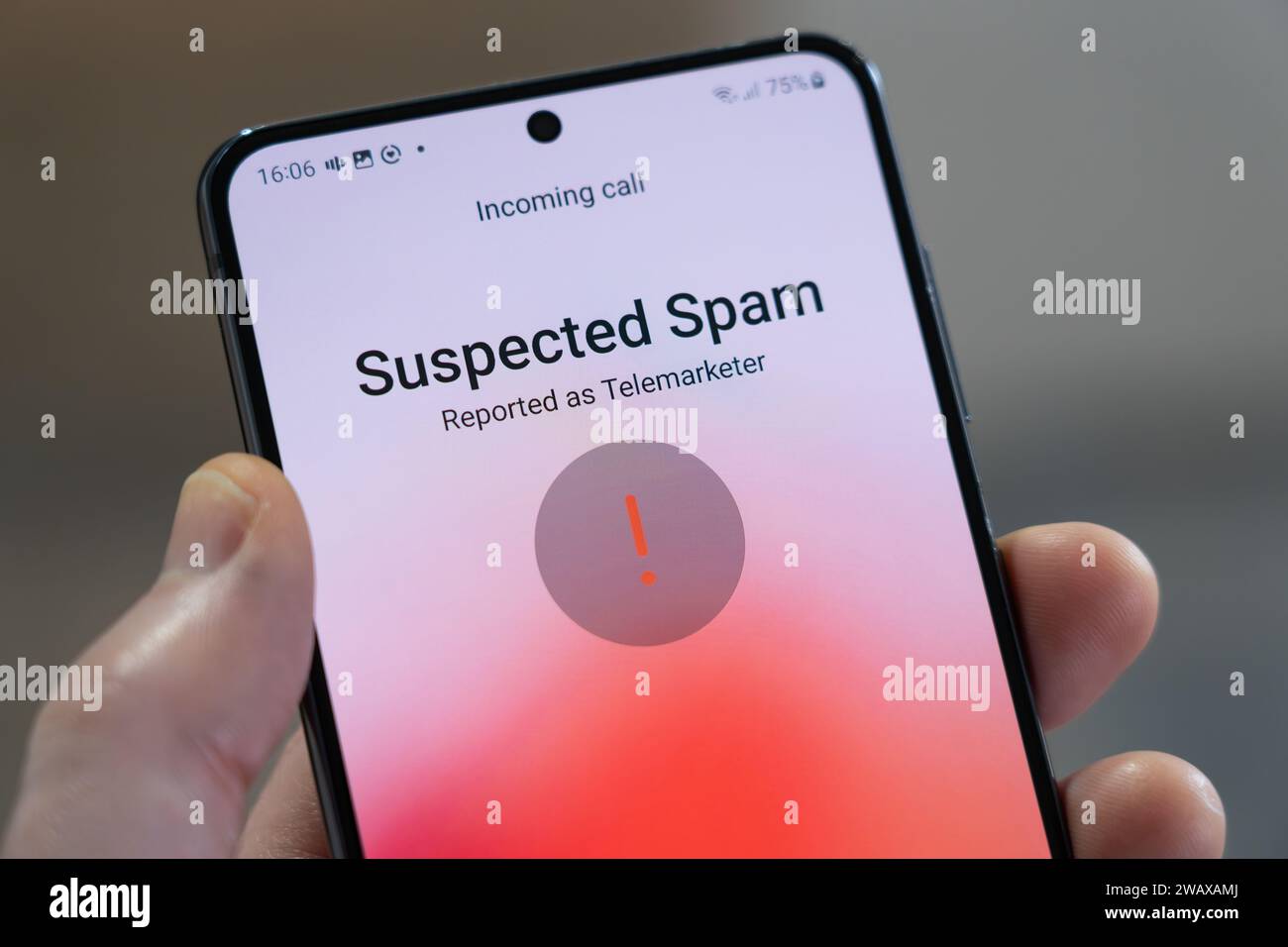 Main tenant un smartphone avec un appel entrant identifié comme étant du spam suspecté et signalé comme étant un télévendeur, Royaume-Uni. Thème : filtrage des spams Banque D'Images