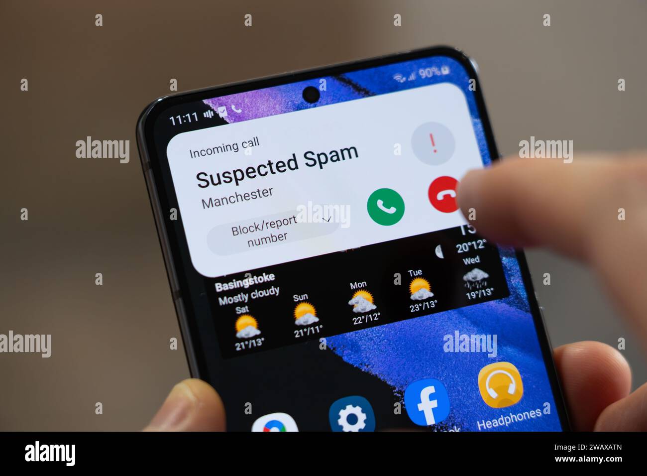 Une personne sur le point de raccrocher lors d'un appel entrant répertorié comme « spam présumé » par un smartphone Android, Royaume-Uni. Thème : appels spam, appel frauduleux, ICO Banque D'Images
