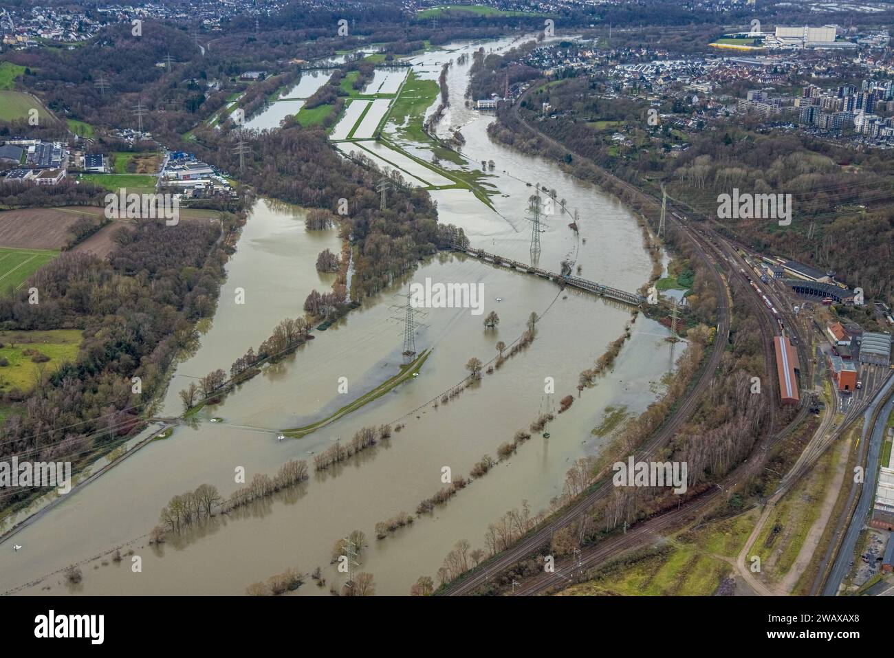 Luftbild, Ruhrhochwasser, Weihnachtshochwasser 2023, Fluss Ruhr tritt nach starken Regenfällen über die Ufer, Überschwemmungsgebiet am Eisenbahnmuseum Bochum, Eisenbahnbrücke und überschwemmte Radbrücke, Bäume und Strommasten im Wasser, hinten das Wasserkraftwerk Horster Mühle mit Schleuse Horst, Dahlhausen, Bochum, Bochum, Ruhrheet Nordrheet Deutschland ACHTUNGxMINDESTHONORARx60xEURO *** vue aérienne, inondation de la Ruhr, inondation de Noël 2023, rivière de la Ruhr déborde ses rives après de fortes pluies, zone inondée au Musée du chemin de fer de Bochum, pont ferroviaire et pont cyclable inondé, arbres et Elect Banque D'Images