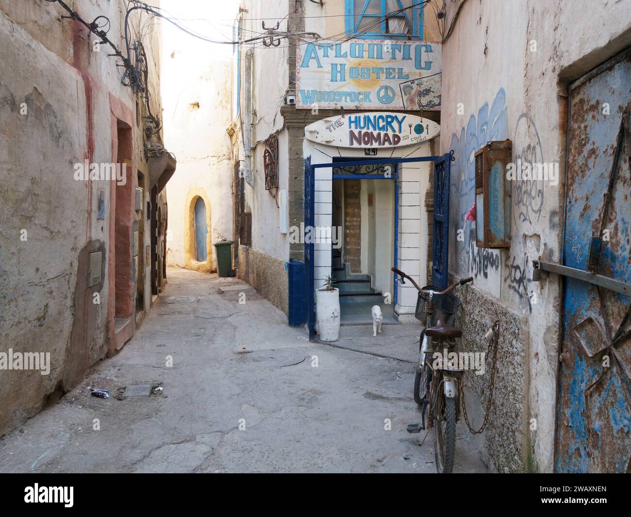 Rue étroite et colorée avec entrée Atlantic Hostel dans la médina historique de la ville d'Essaouira, Maroc. 7 janvier 2024 Banque D'Images