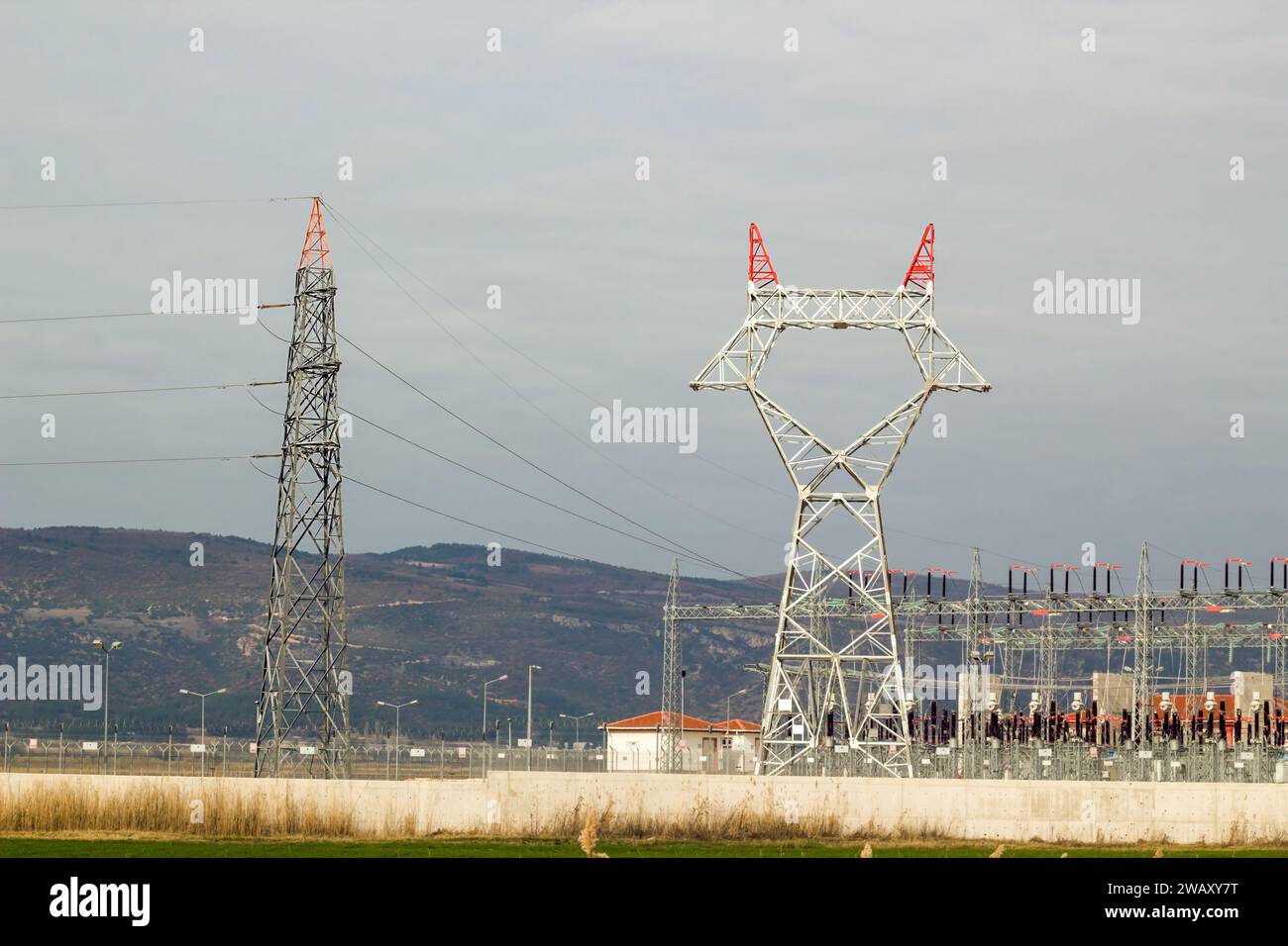 Grand poteau électrique avec des câbles en acier pas encore connectés est avec la centrale électrique, dans la campagne Banque D'Images