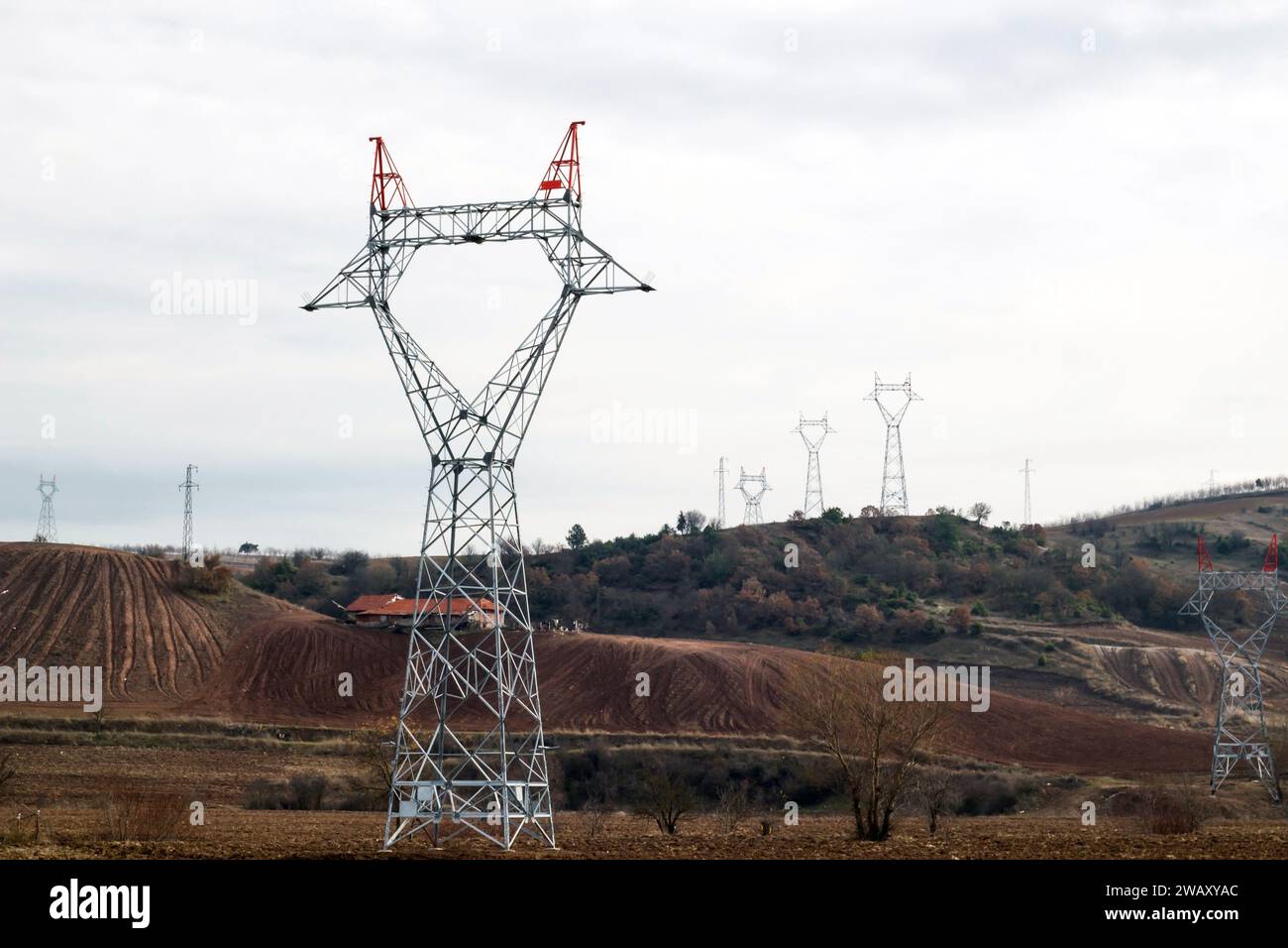 Grand poteau électrique avec des câbles en acier pas encore connectés est avec la centrale électrique, dans la campagne Banque D'Images