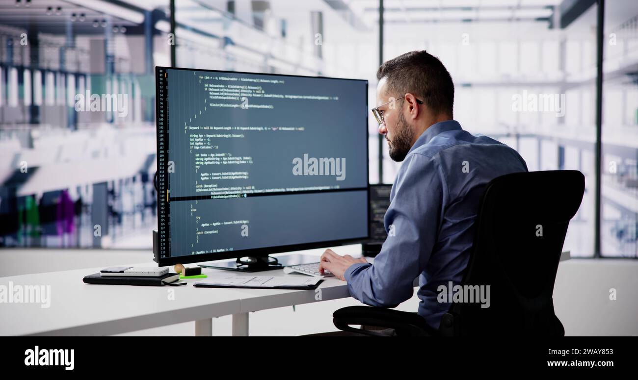 Programmeur de logiciel ou Coder Man utilisant un ordinateur de bureau Banque D'Images