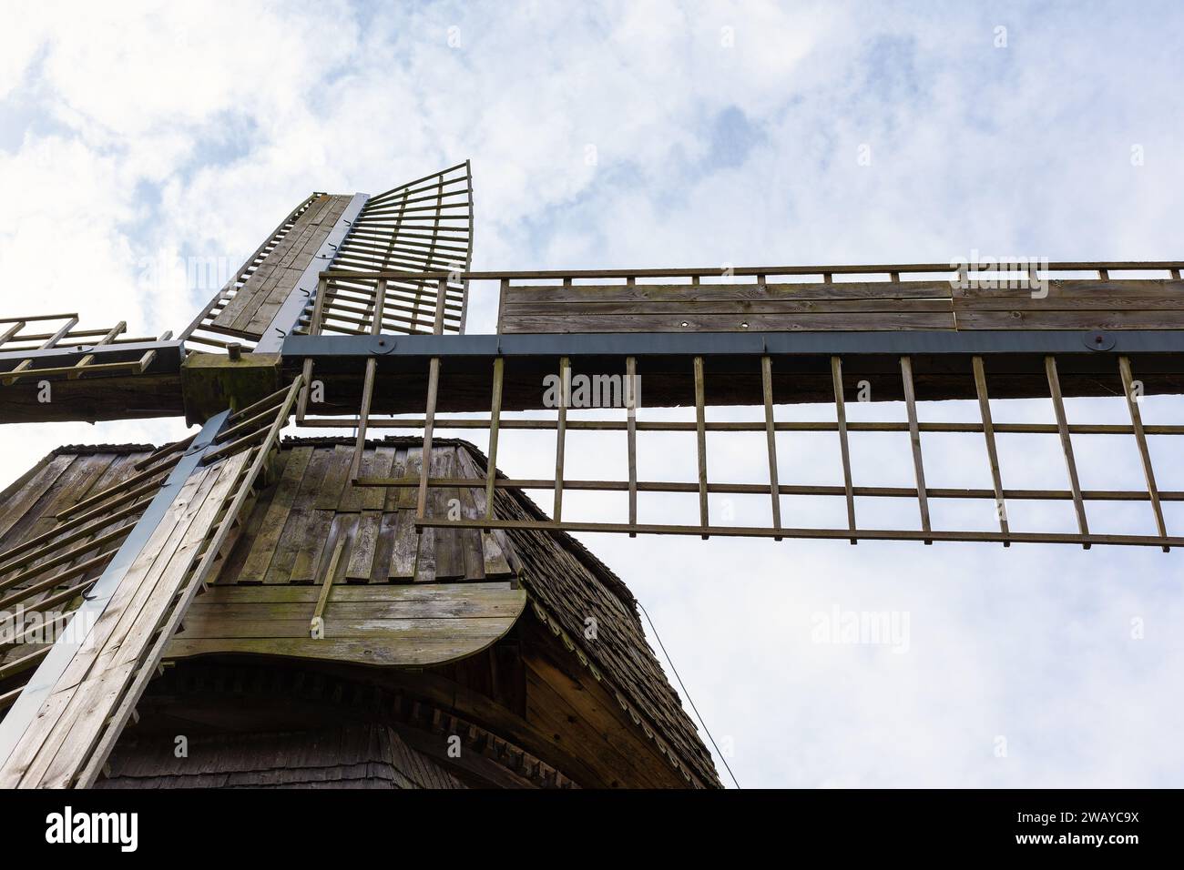 Les ailes d'un ancien moulin en bois sont photographiées d'en bas sur un fond de ciel bleu. Banque D'Images