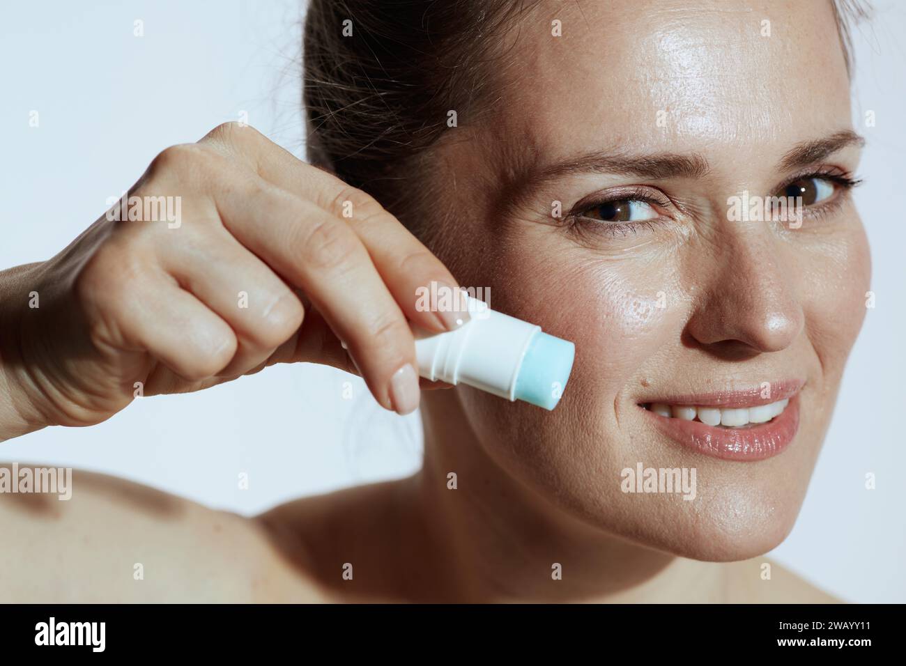 souriant femme de 40 ans avec bâton de surligneur isolé sur fond blanc. Banque D'Images