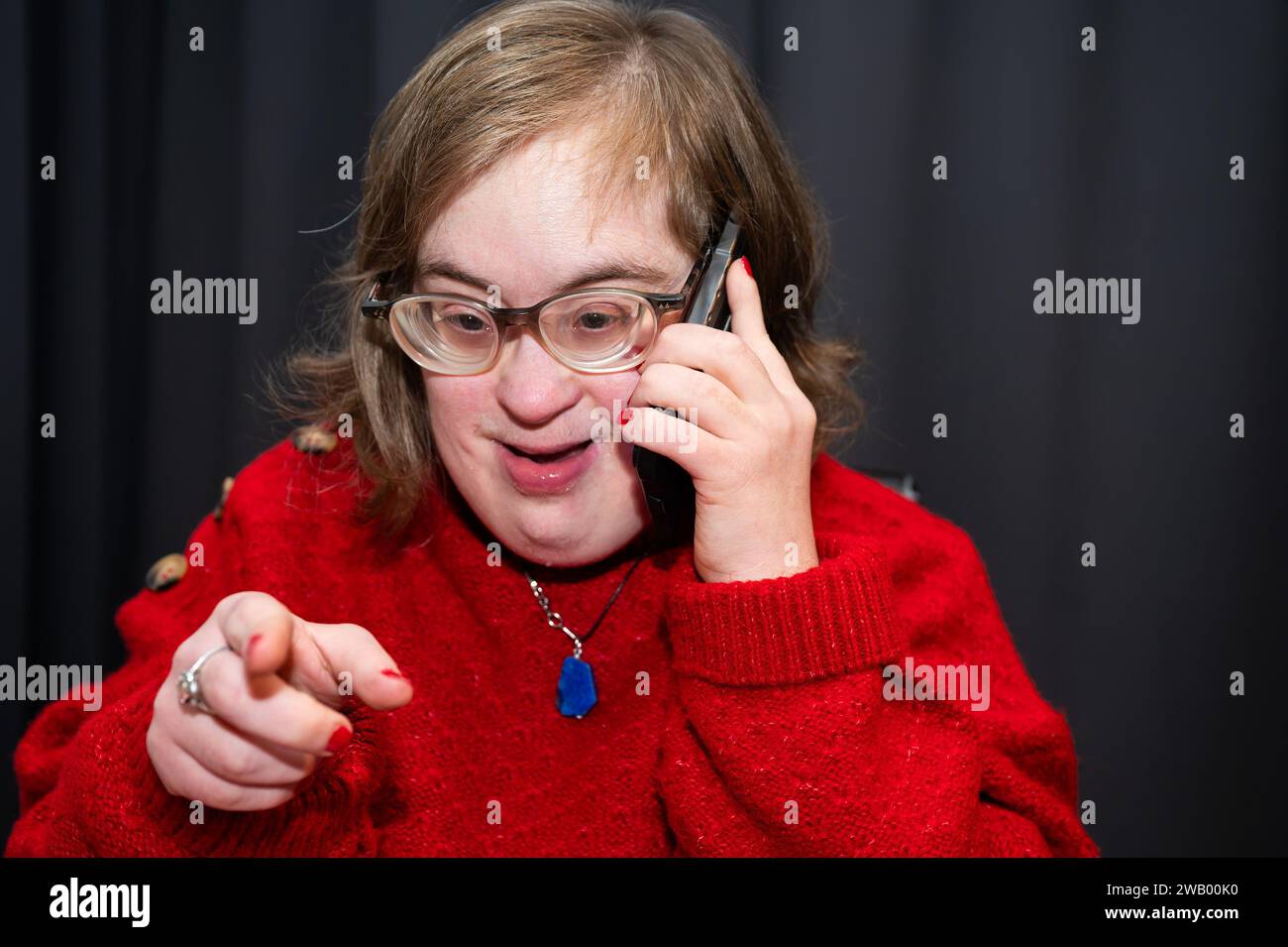 Heureuse femme de 41 ans avec le syndrome de Down appelant sa famille, Bruxelles, Belgique Banque D'Images