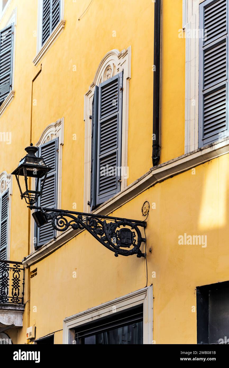 Lampadaire pittoresque avec un mur peint avec la couleur traditionnelle 'giallo parma', dans le centre-ville de Parme, région Emilie Romagne, Italie Banque D'Images