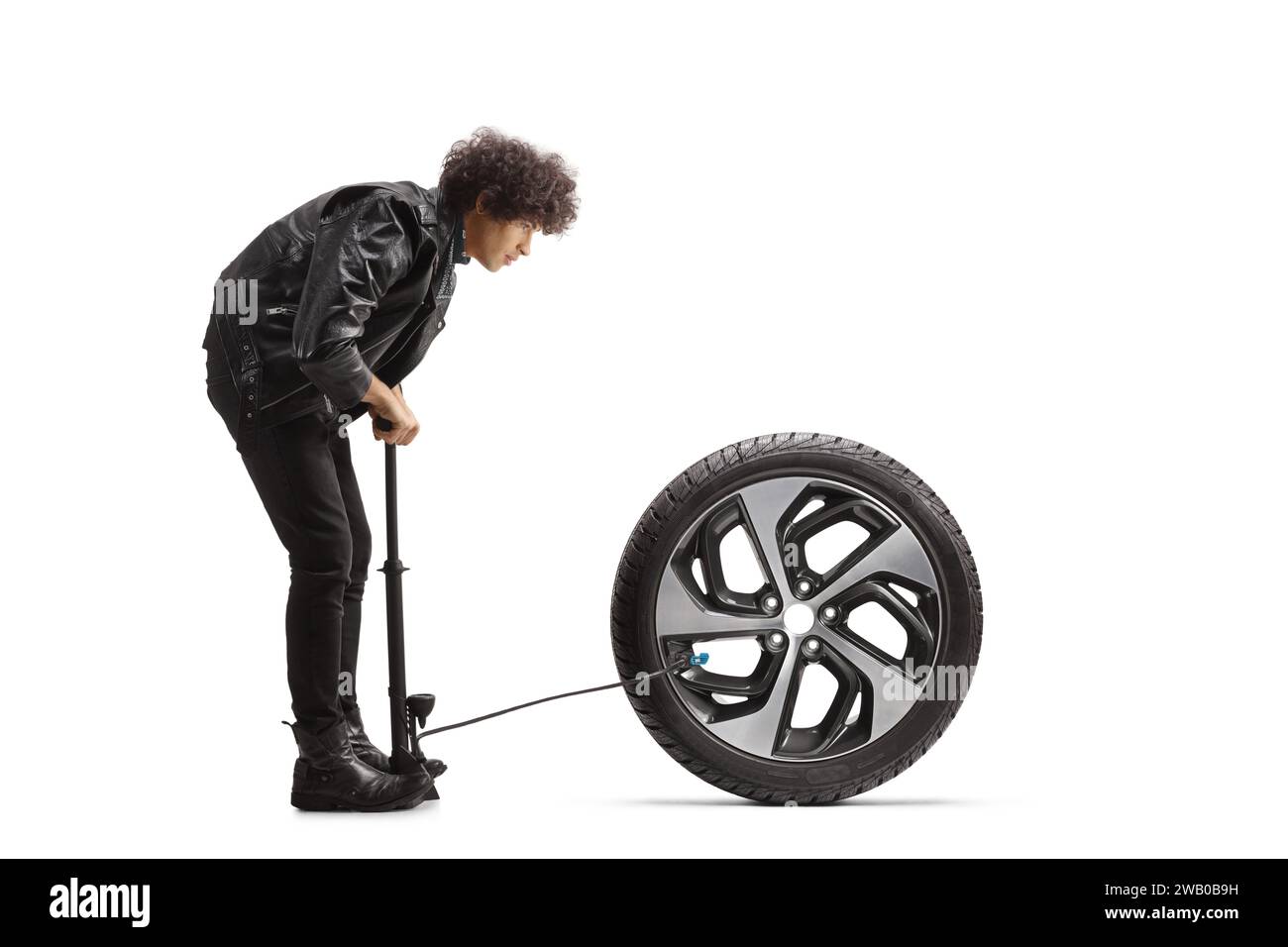 Jeune homme pompant un pneu de voiture isolé sur fond blanc Banque D'Images