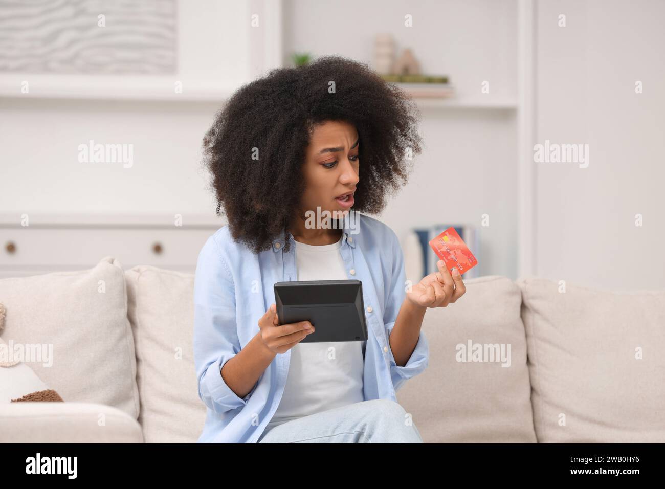 Femme confuse avec calculatrice et budget de planification de carte de crédit à la maison. Problème de dette Banque D'Images