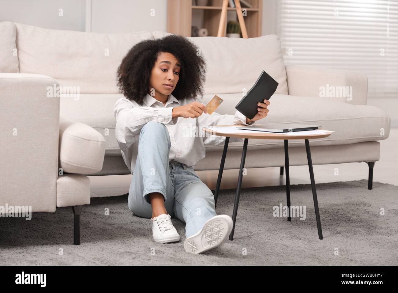 Femme confuse avec calculatrice et budget de planification de carte de crédit à la maison. Problème de dette Banque D'Images