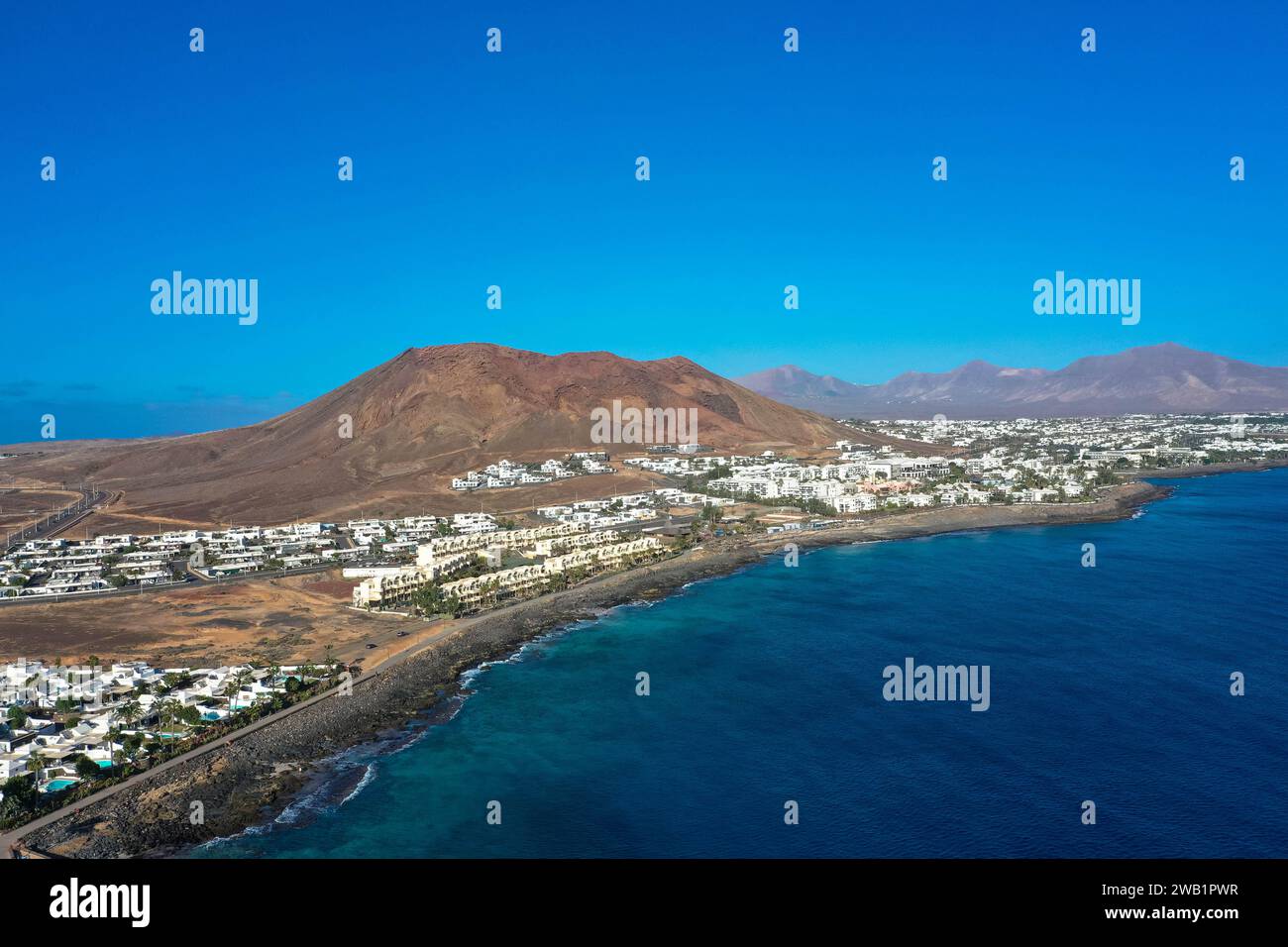 Côte de Playa Blanca. Vue panoramique drone aérien avec volcan rouge en arrière-plan. Tourisme et concept de vacances. Flamingo Beach Lanzarote, Canar Banque D'Images