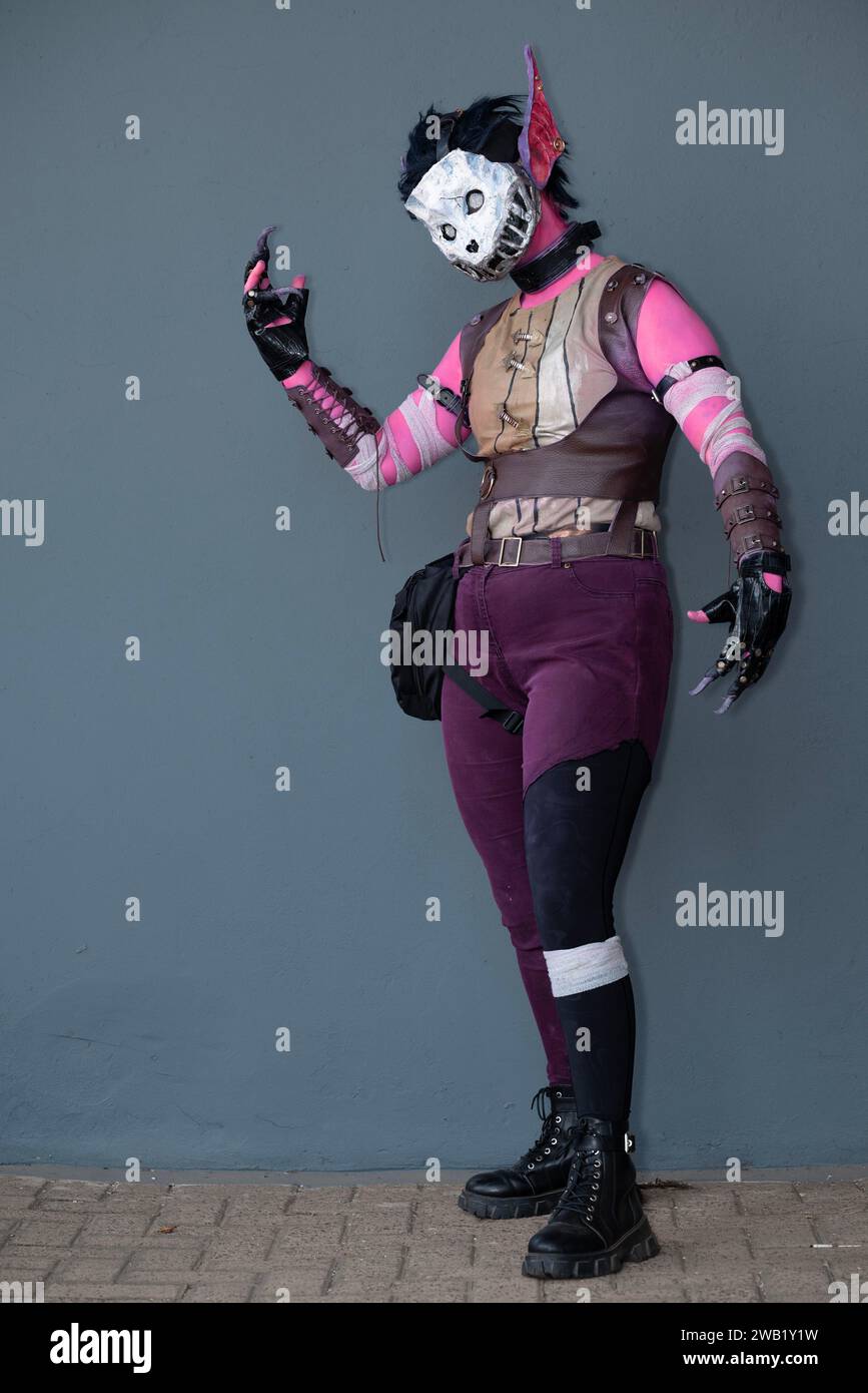 Une cosplayeuse habillée comme un monstre rose avec un masque de crâne Banque D'Images