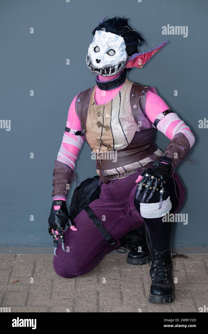 Une cosplayeuse habillée comme un monstre rose avec un masque de crâne Banque D'Images