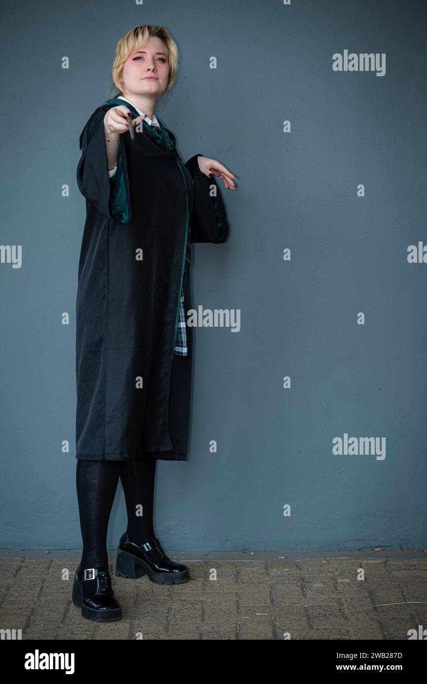 Une cosplayeuse blonde caucasienne habillée comme un sorcier avec une baguette magique Banque D'Images