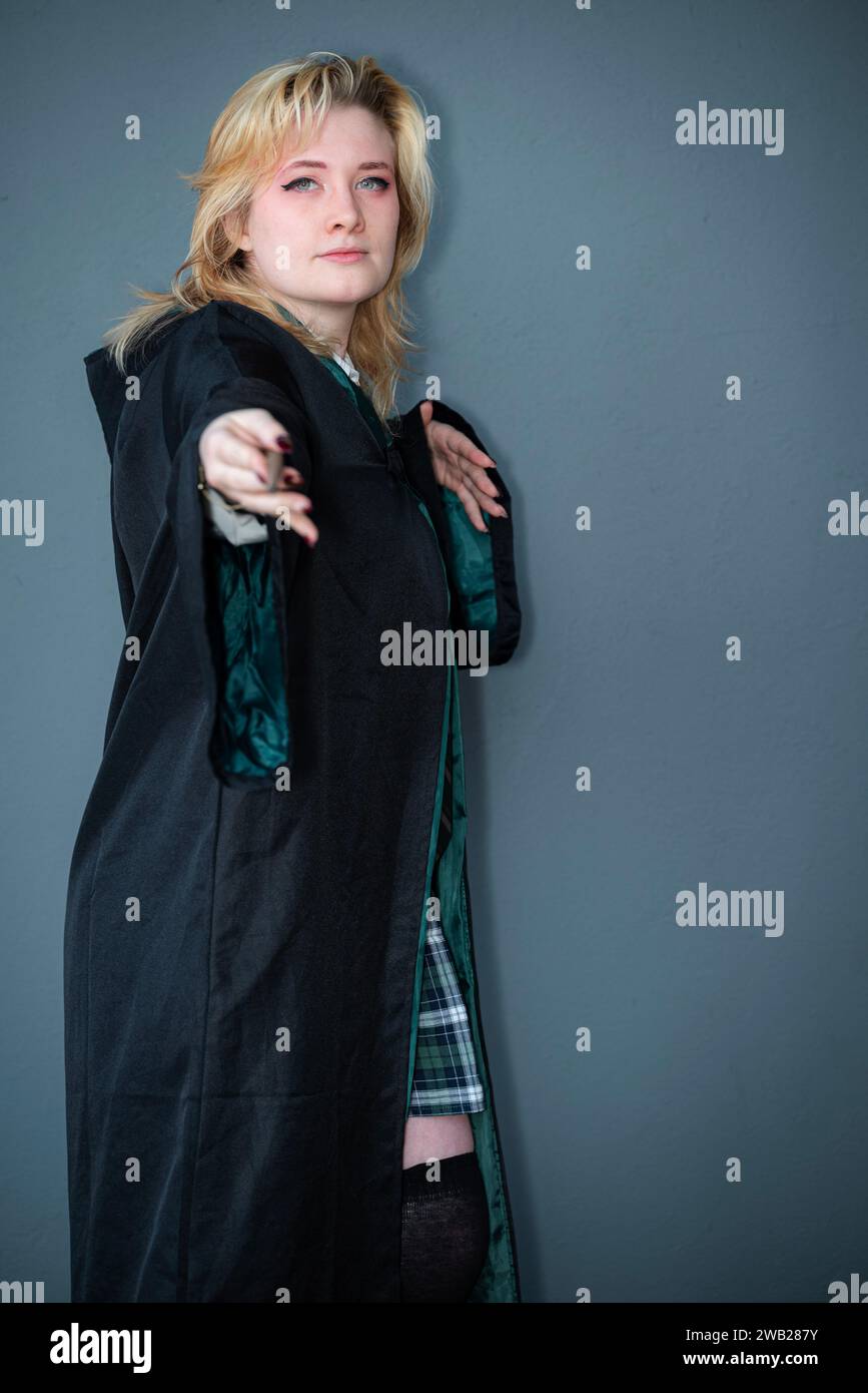 Une cosplayeuse blonde caucasienne habillée comme un sorcier avec une baguette magique Banque D'Images