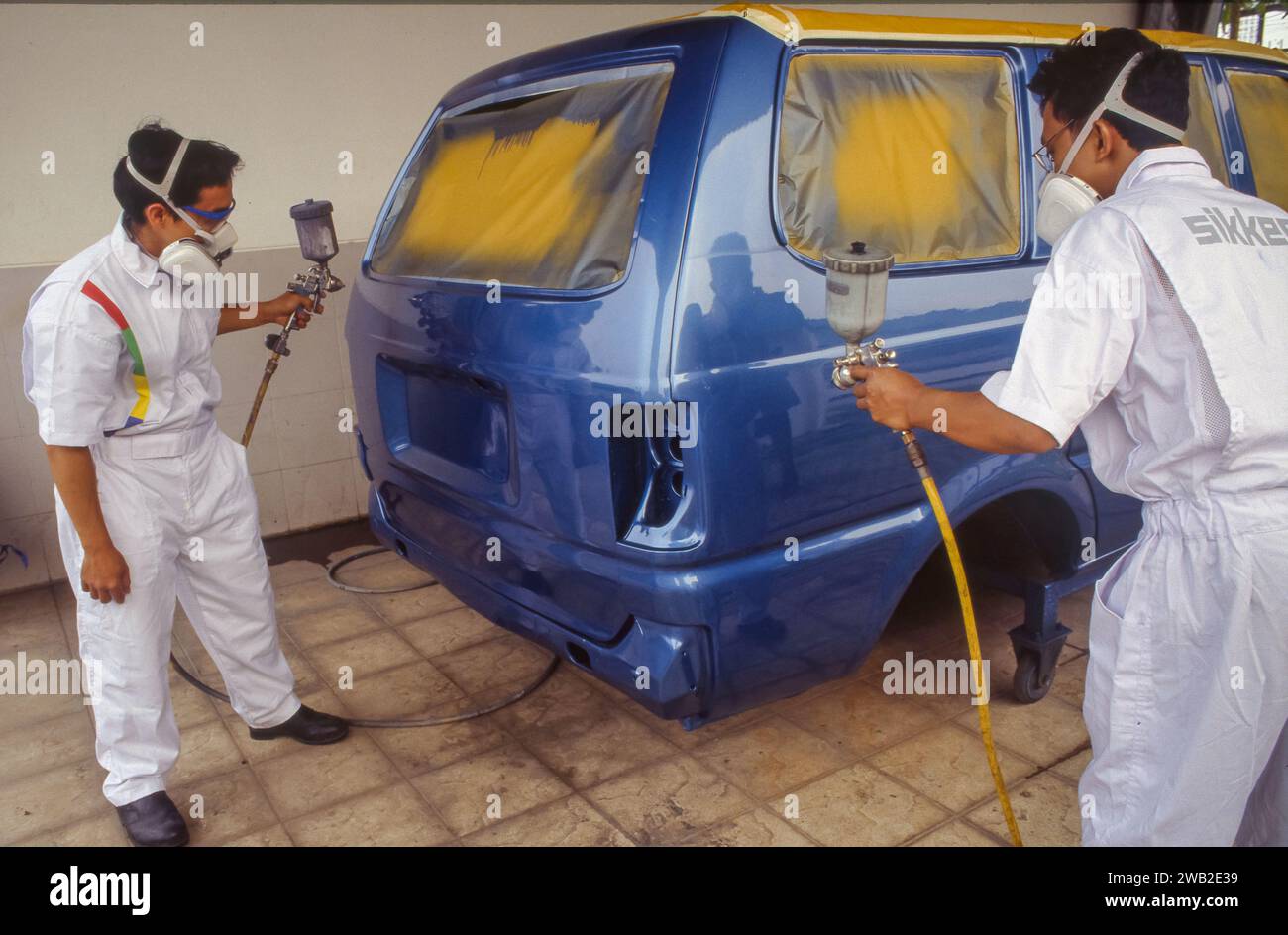 Indonésie, Jakarta - des ouvriers d'atelier de peinture automobile portant des masques de protection au travail. Banque D'Images