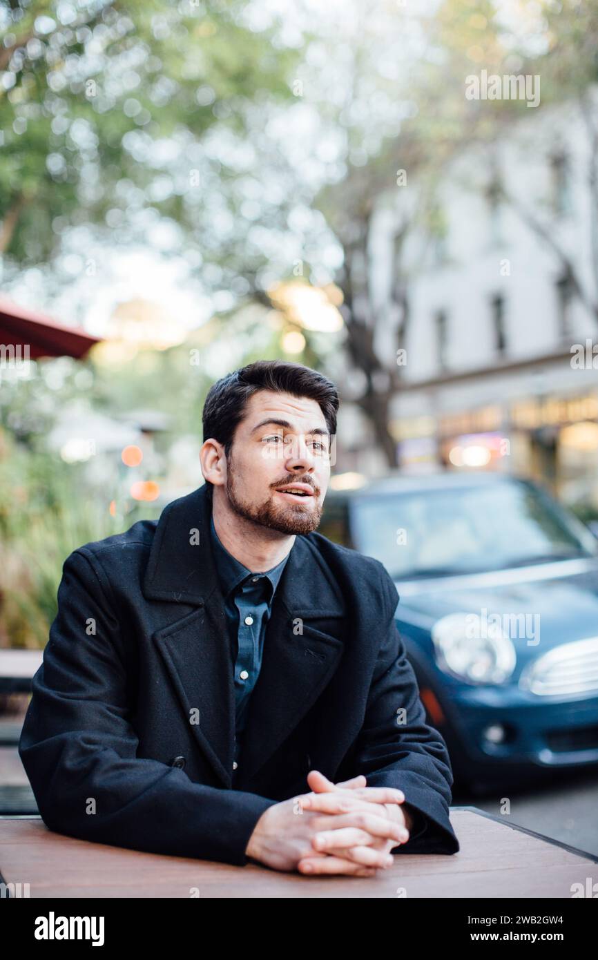 Homme rencontrant quelqu'un dehors à table Banque D'Images