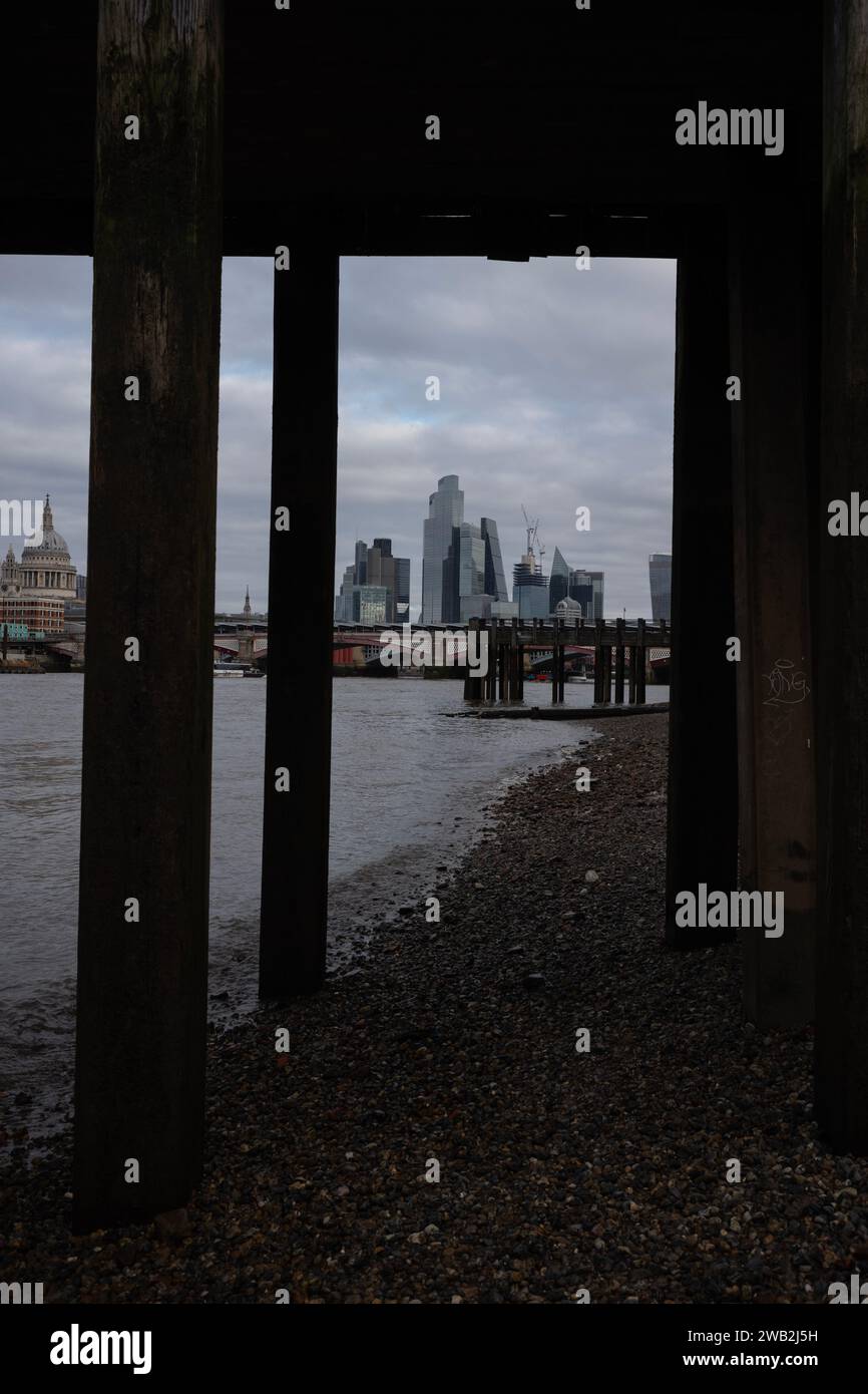 Vue sur la rive vers la City de Londres, depuis le dessous des anciennes jetées en bois, Southbank, centre de Londres, Angleterre, Royaume-Uni Banque D'Images