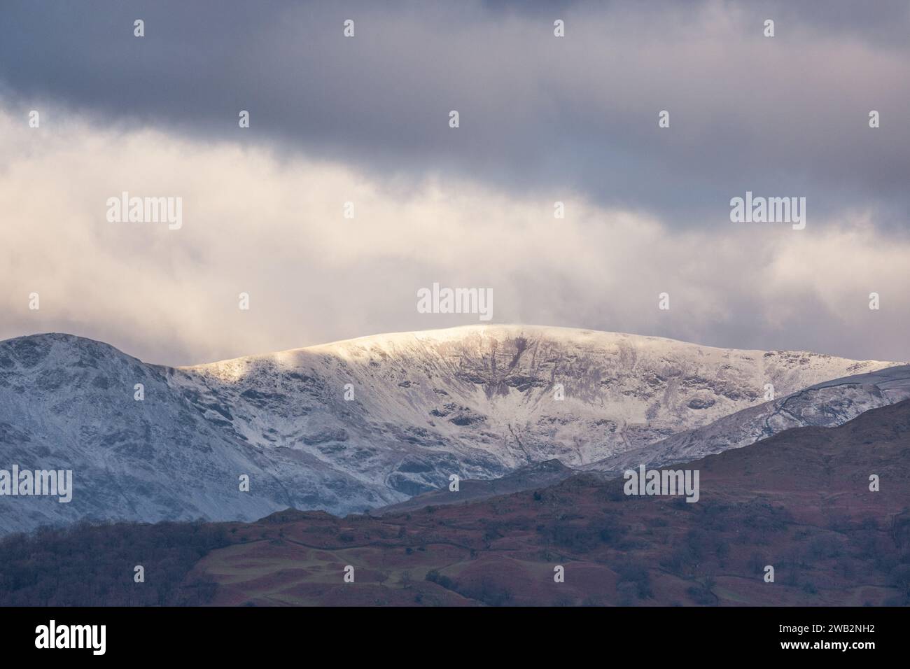Cumbria, Royaume-Uni. 8 janvier 2024. UK Météo.neige sur la chute le Faifield Horseshoe (2864ft au-dessus du niveau de la mer) vu de Windermere Village le Lake District . Crédit : Gordon Shoosmith/Alamy Live News Banque D'Images