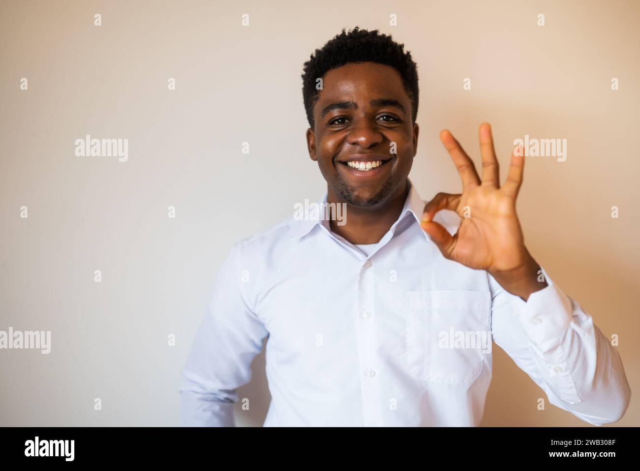 Portrait d'homme heureux qui sourit et montre un excellent signe. Copiez l'espace sur l'image pour votre texte ou publicité. Banque D'Images