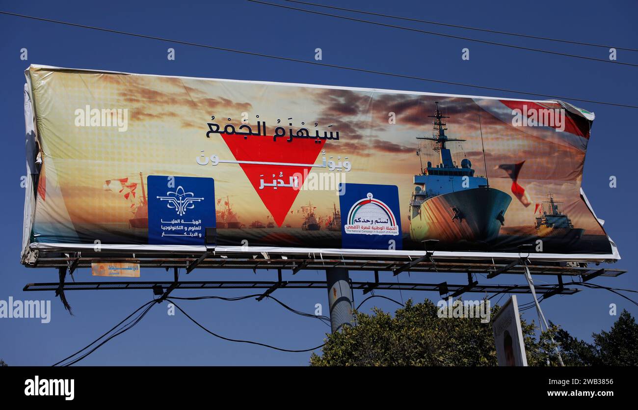 SANAA, Sanaa, Yémen. 8 janvier 2024. 8 janvier 2024, Sanaa, Yémen : un panneau d'affichage portant une photo de cuirassés américains, et des mots lisant en arabe ' la foule sera vaincue et ils tourneront le dos ''. Les Houthis ont déclaré leur intention de bloquer les navires israéliens, ou ceux appartenant à des sociétés israéliennes, de transiter par le détroit de Bab al-Mandab jusqu’à ce qu’Israël cesse son assaut sur Gaza. Au cours des dernières semaines, janvier, les Houthis ont intensifié leurs attaques contre les navires marchands en utilisant des missiles, des drones et des drones. Ces attaques ont perturbé la circulation le long Banque D'Images