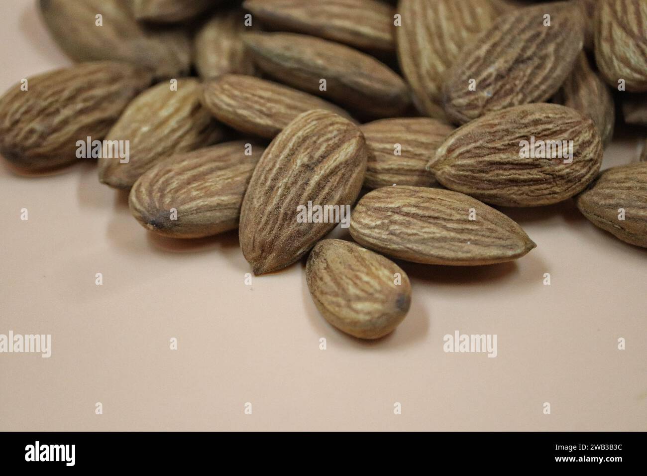 Un gros plan d'un tas d'amandes sur un fond beige. Banque D'Images