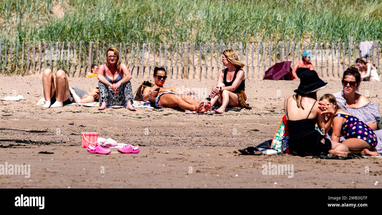 Par une chaude journée glorieuse à Dundee, les femmes locales prennent le soleil le long de la plage de Broughty Ferry pendant la canicule estivale en Écosse, au Royaume-Uni Banque D'Images